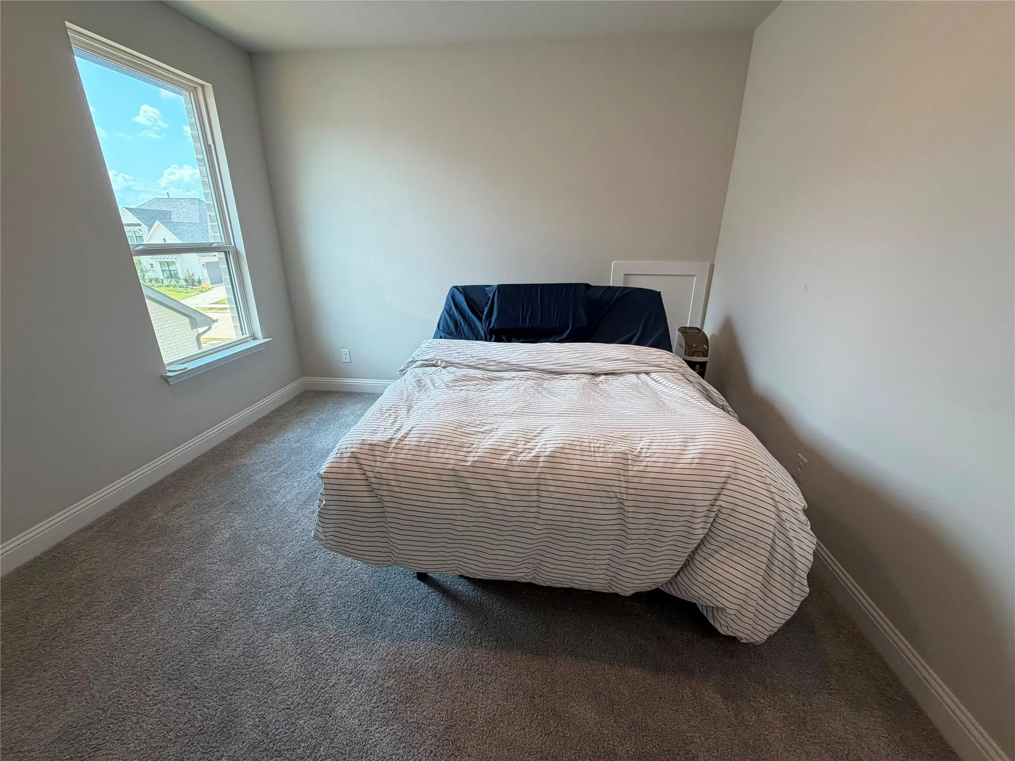 Neutral tone wall paint, carpet flooring, and a large window