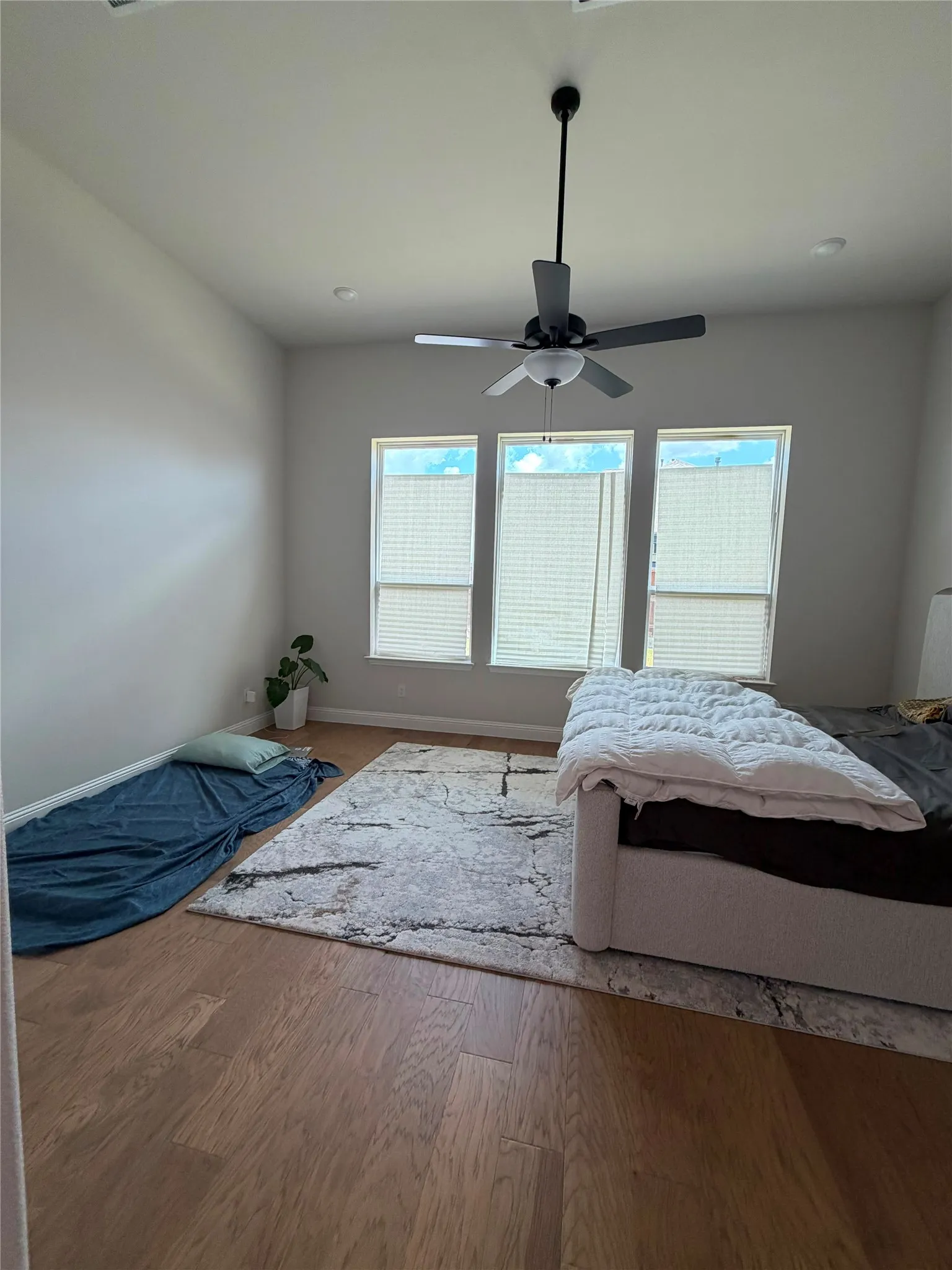 Hardwood flooring, recessed lighting, ceiling fan, and three windows with blinds