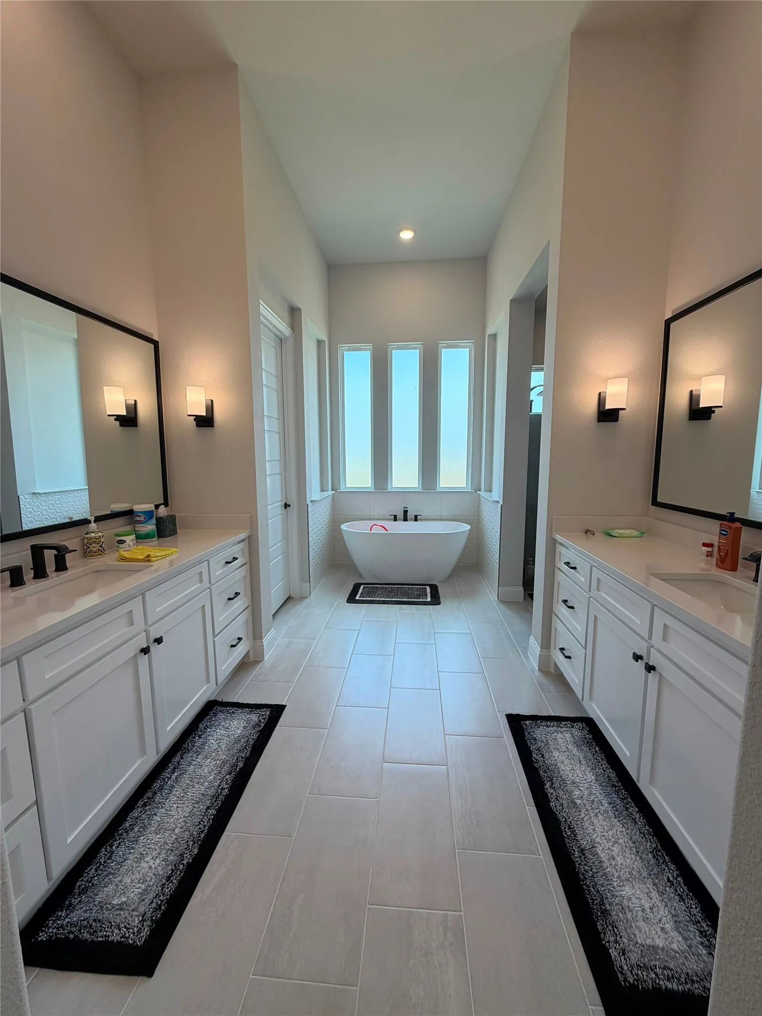 Dual vanities with white cabinetry, square vessel sinks, and matte black fixtures
