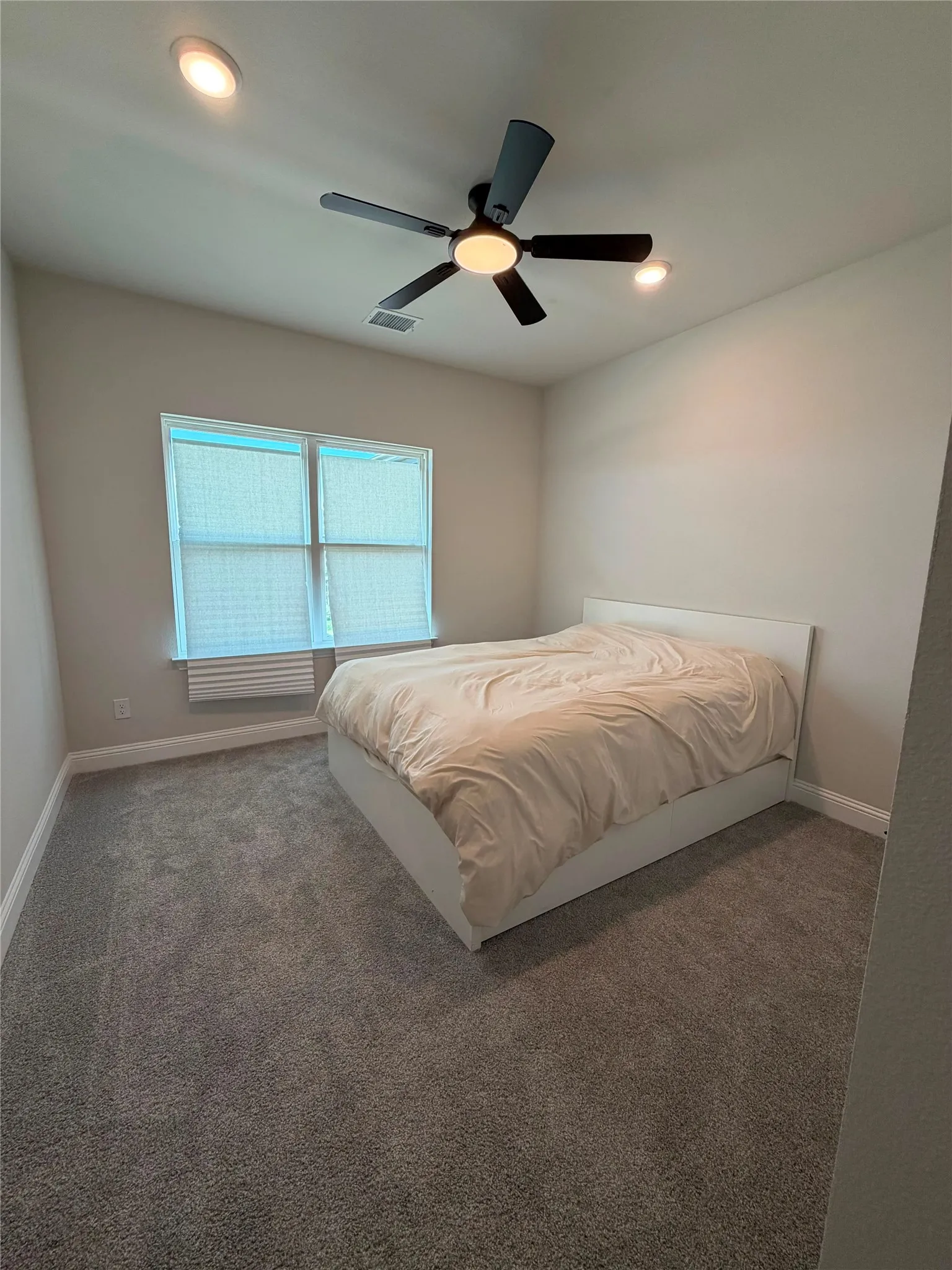 Ceiling fan with integrated light, recessed ceiling lights, wall-to-wall carpeting, and window with blinds
