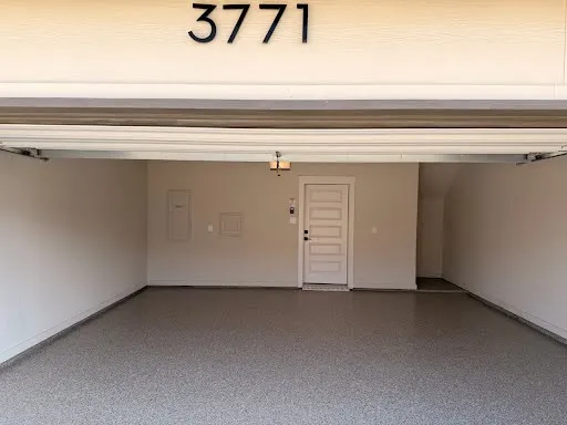 Epoxy-finished flooring, recessed storage space, ceiling-mounted light fixture, paneled interior door, and exterior address numbers