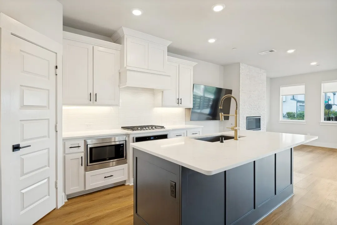 White shaker cabinetry and a large kitchen island with a quartz countertop , oversized gas cooktop.  Mrs CLEAN lived here.. Original owners just moved to their new home. NEVER RENTED and it SHOWS