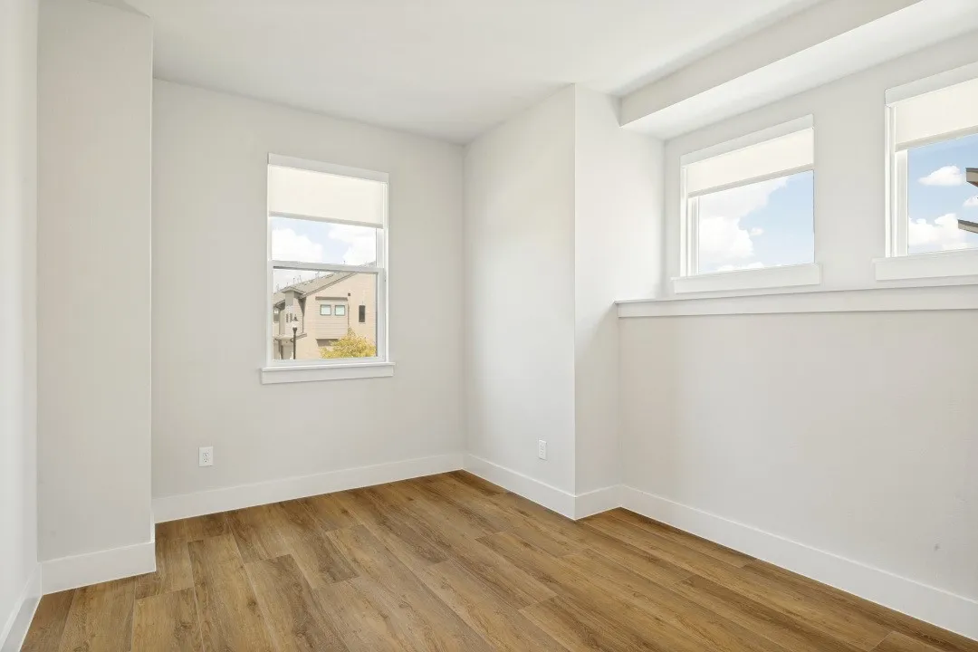Wood-finish flooring, multiple windows, and bright white walls