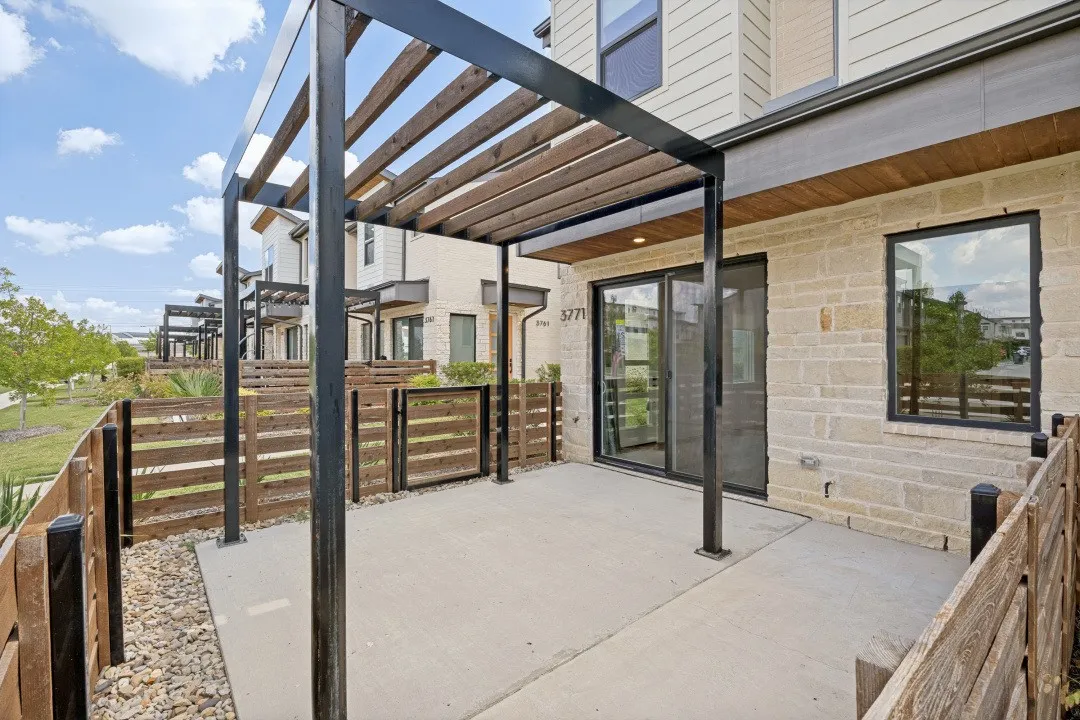 Private patio featuring a pergola, concrete hardscaping, and horizontal slatted wood fencing