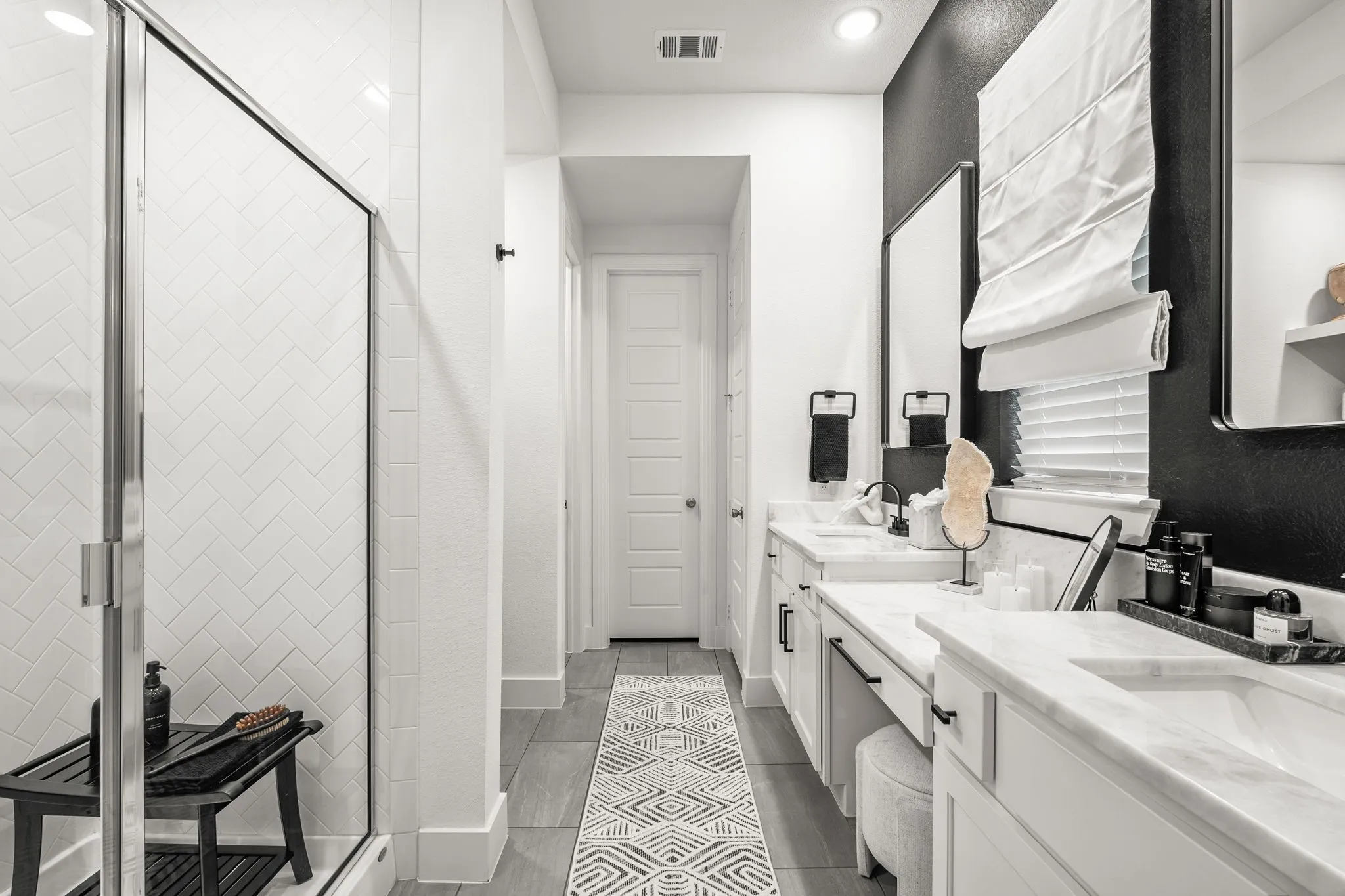 Spacious primary bath with shower, dual sinks, vanity sitting area, linen closet, privacy commode and walk-in closet.