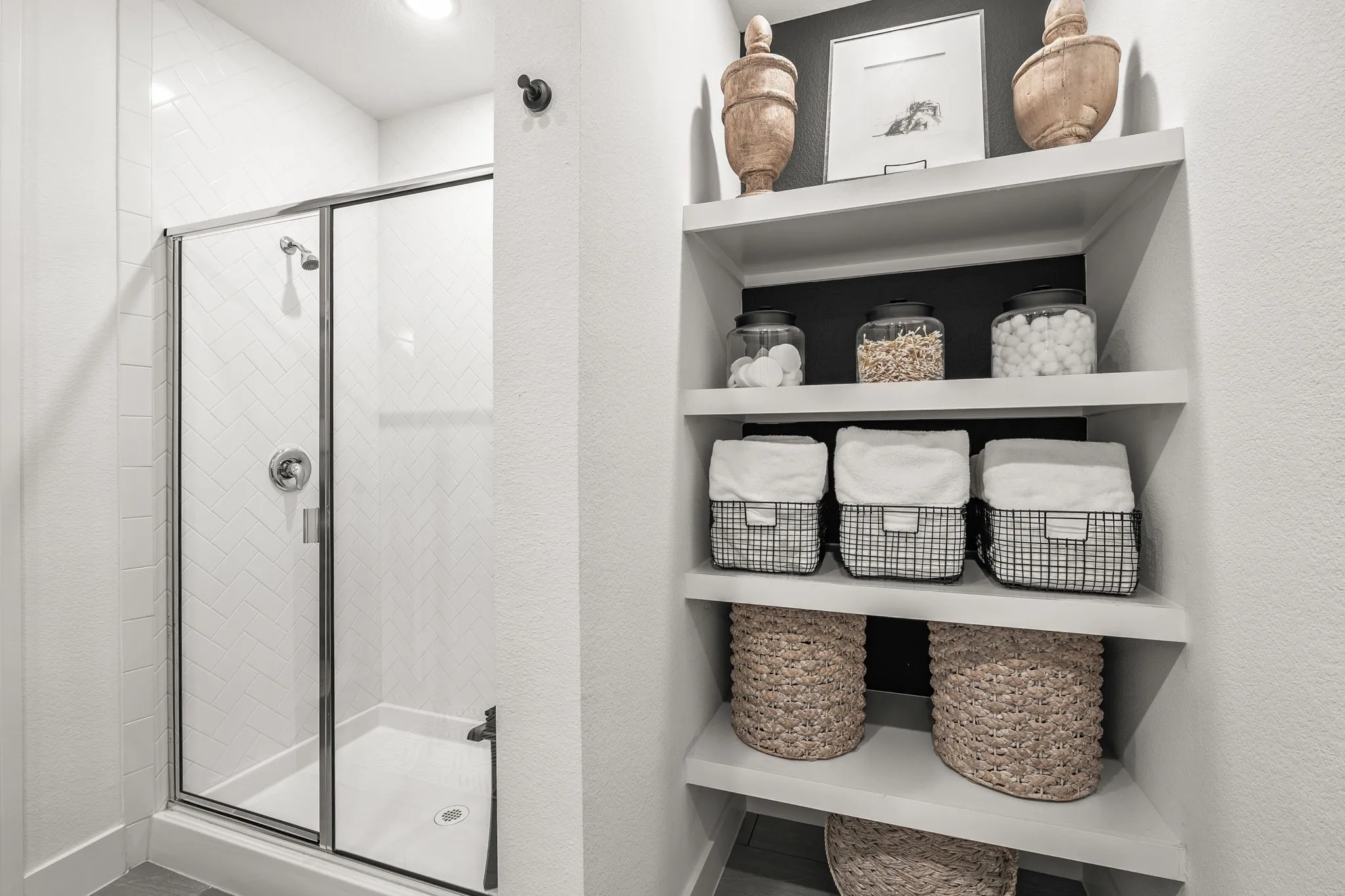 Extended, oversized shower in primary bath with quality built in shelving great for storage. There is also a linen closet in the bathroom.