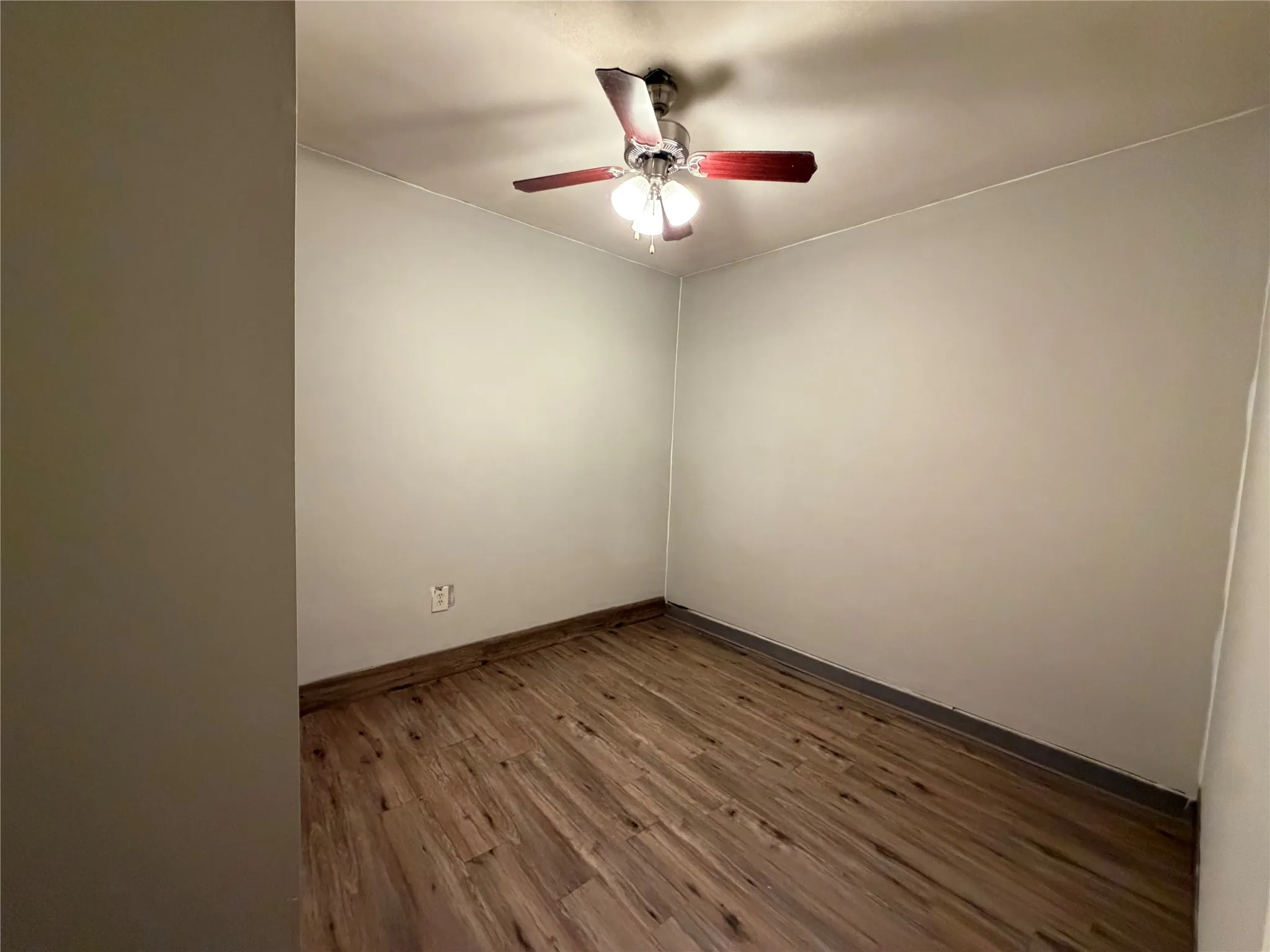 Wood-finish flooring with a ceiling fan light fixture