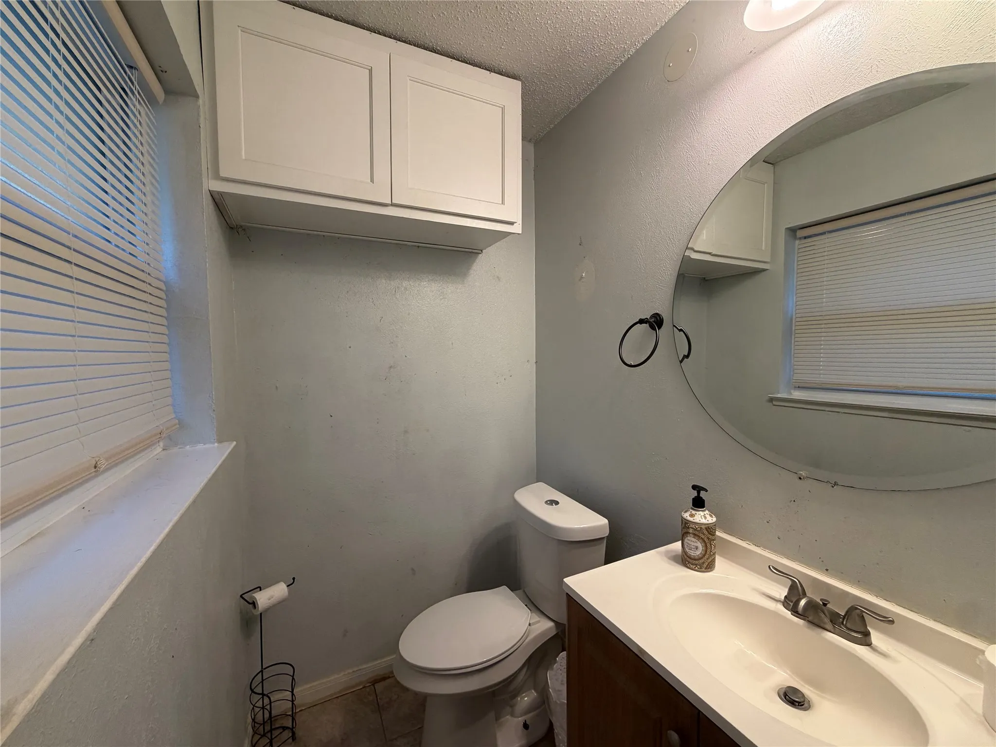 White shaker-style cabinetry with a built-in vanity, integrated sink, and an overhead light fixture
