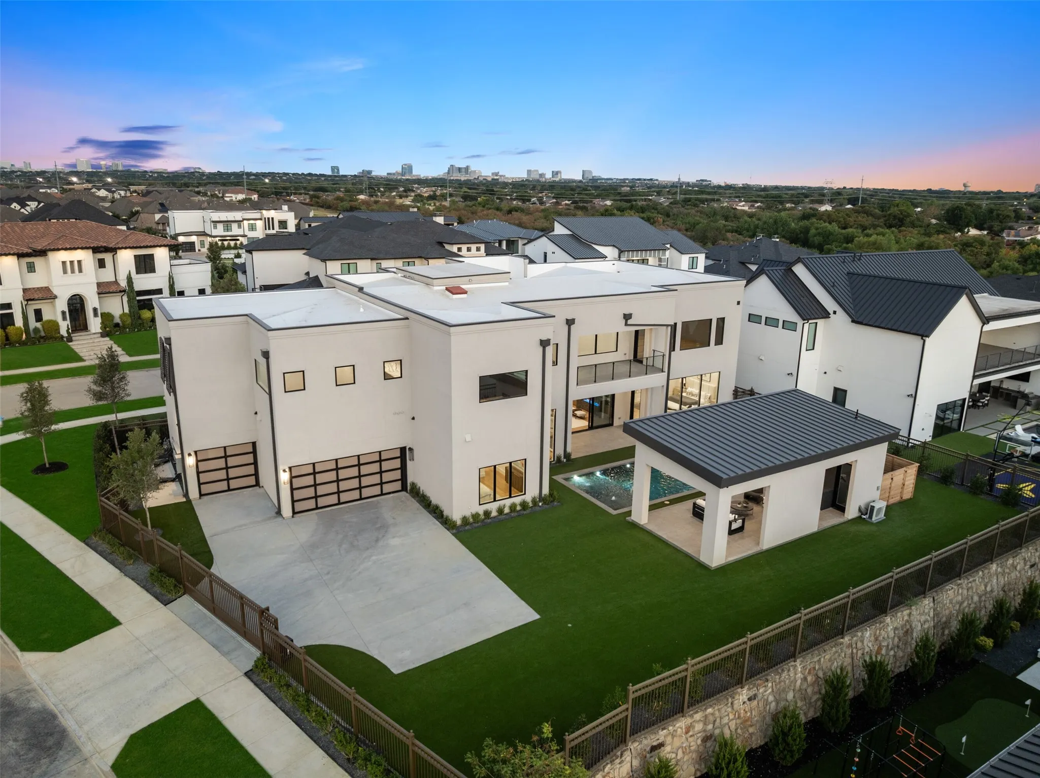 Modern architecture featuring two attached garages with opaque panel doors, a private balcony, an outdoor pool, and an ancillary structure with a metal roof