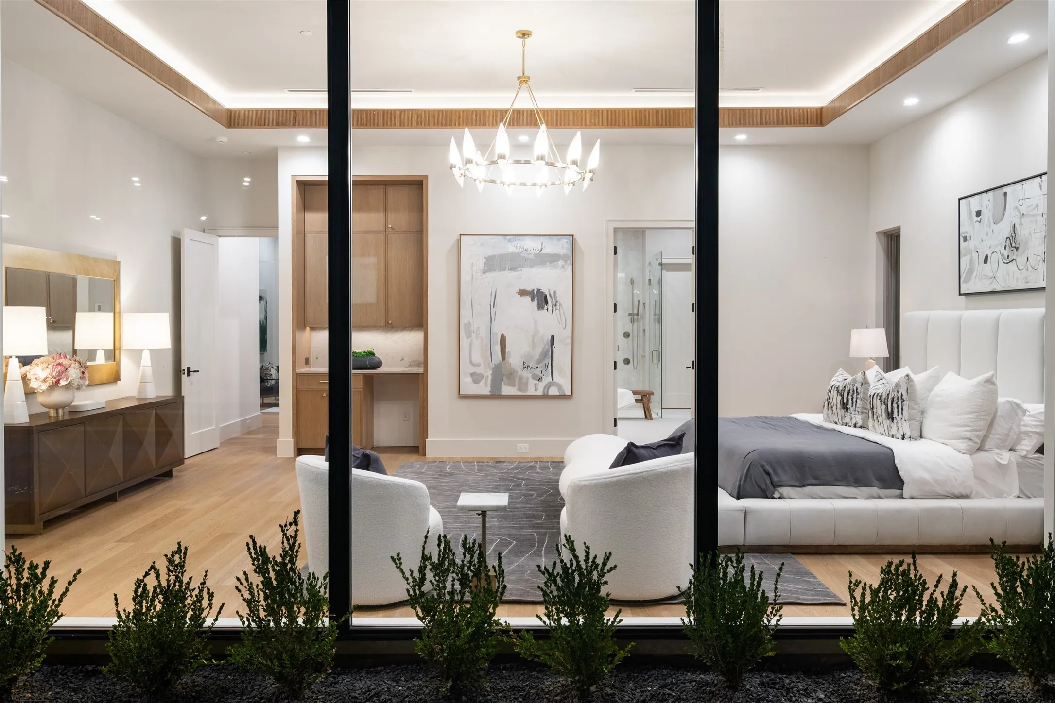 Expansive glass paneling, wood-finish flooring, recessed lighting, and a tray ceiling with accent lighting