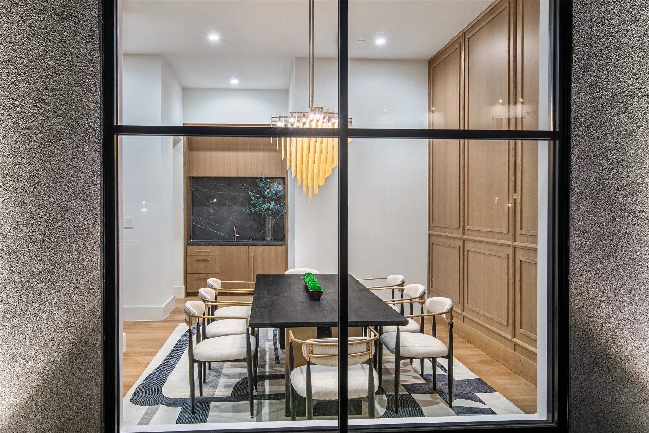 Wood-finish flooring, built-in cabinetry, recessed lighting, and a linear chandelier
