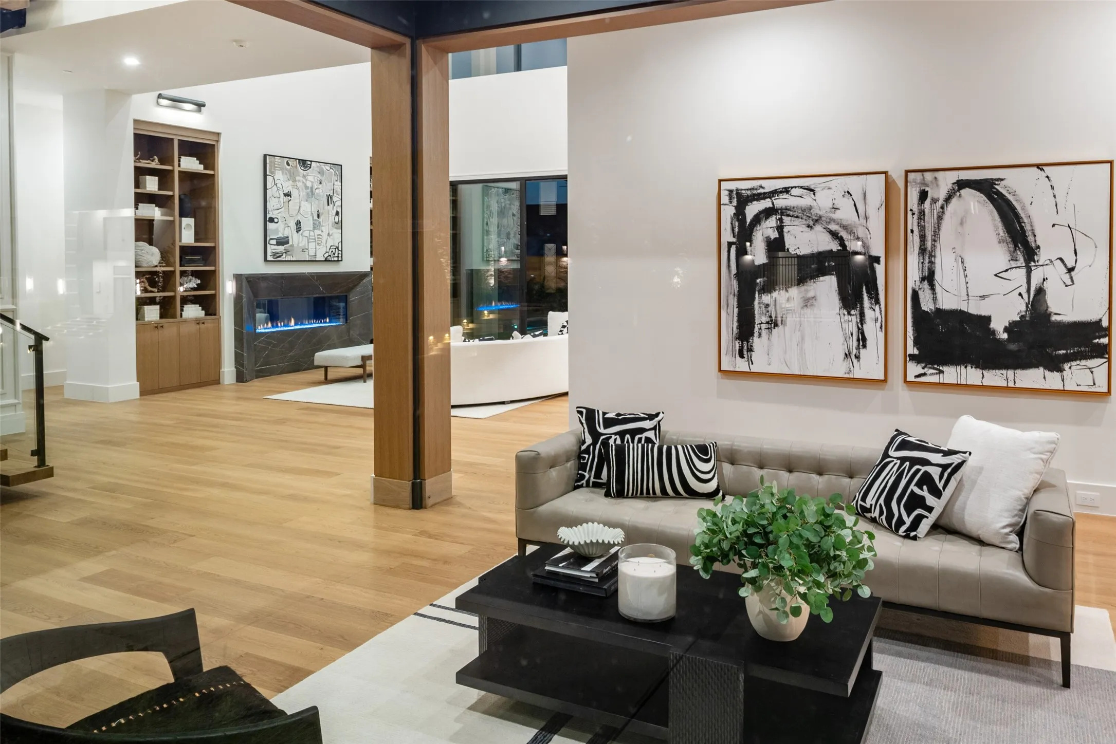 Wood-finish flooring, built-in shelving, linear fireplace, and expansive windows