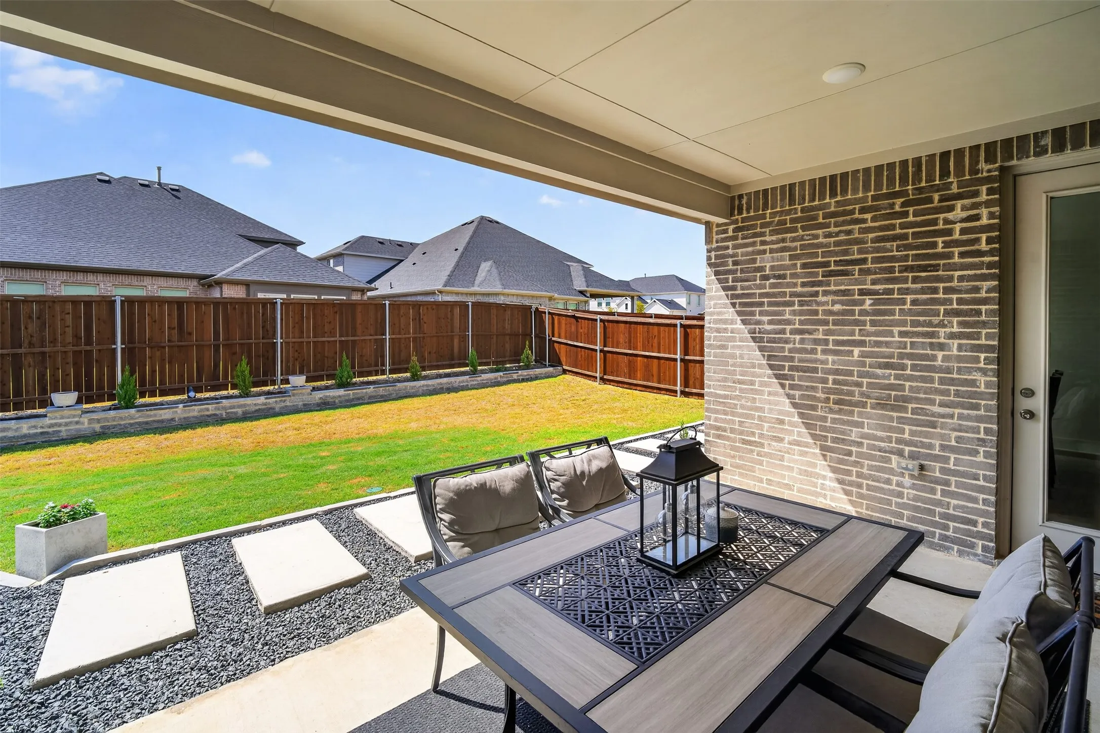 Covered patio with brick exterior, concrete flooring, and recessed lighting