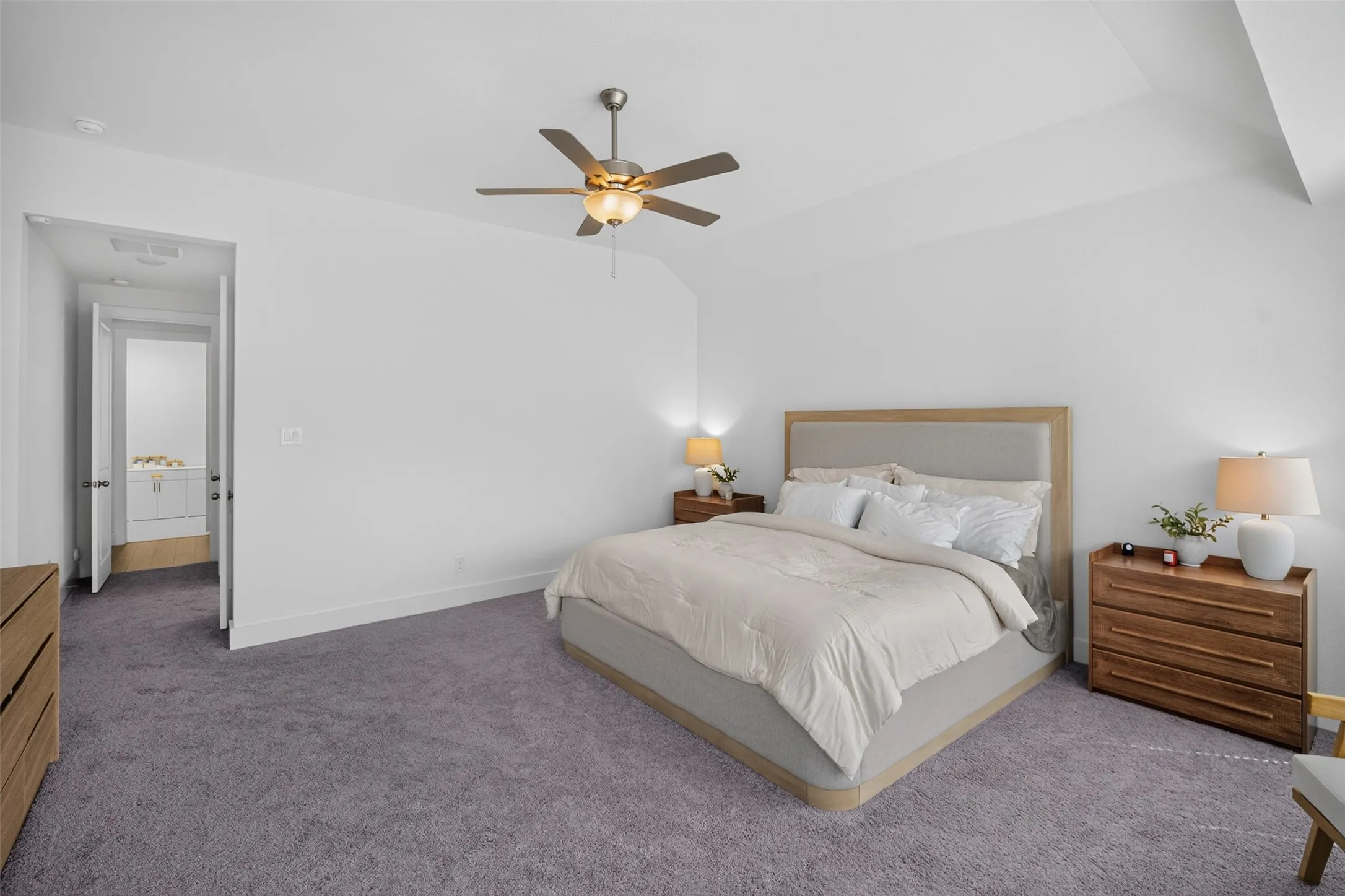 Tray ceiling with a ceiling fan, light gray carpeting, and a white wall finish