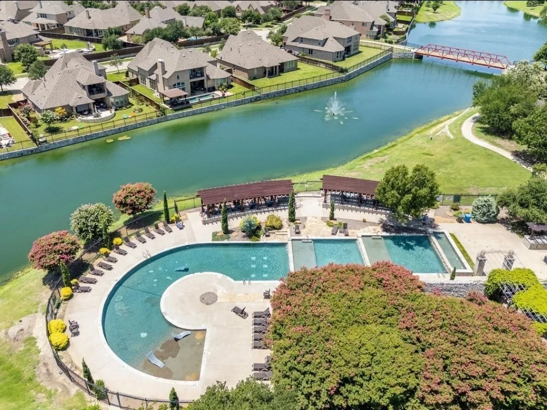 Community pool area featuring multiple swimming pools, covered pergolas, and a paved lounge area