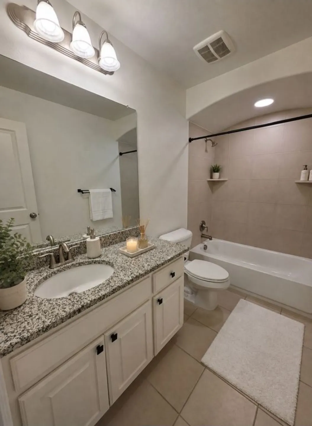 Vanity with granite countertop, integrated sink, and white cabinetry