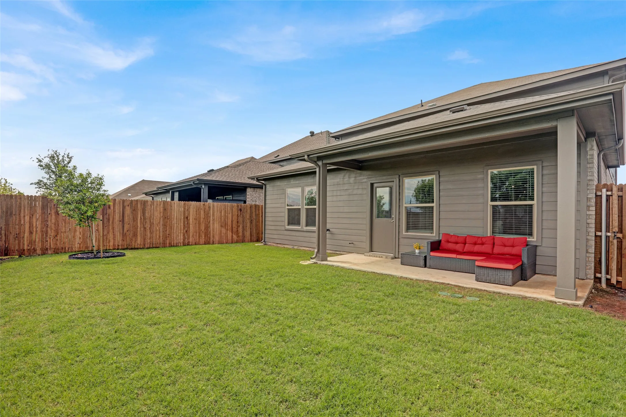 Back of property featuring a fenced backyard, outdoor lounge area, and a patio