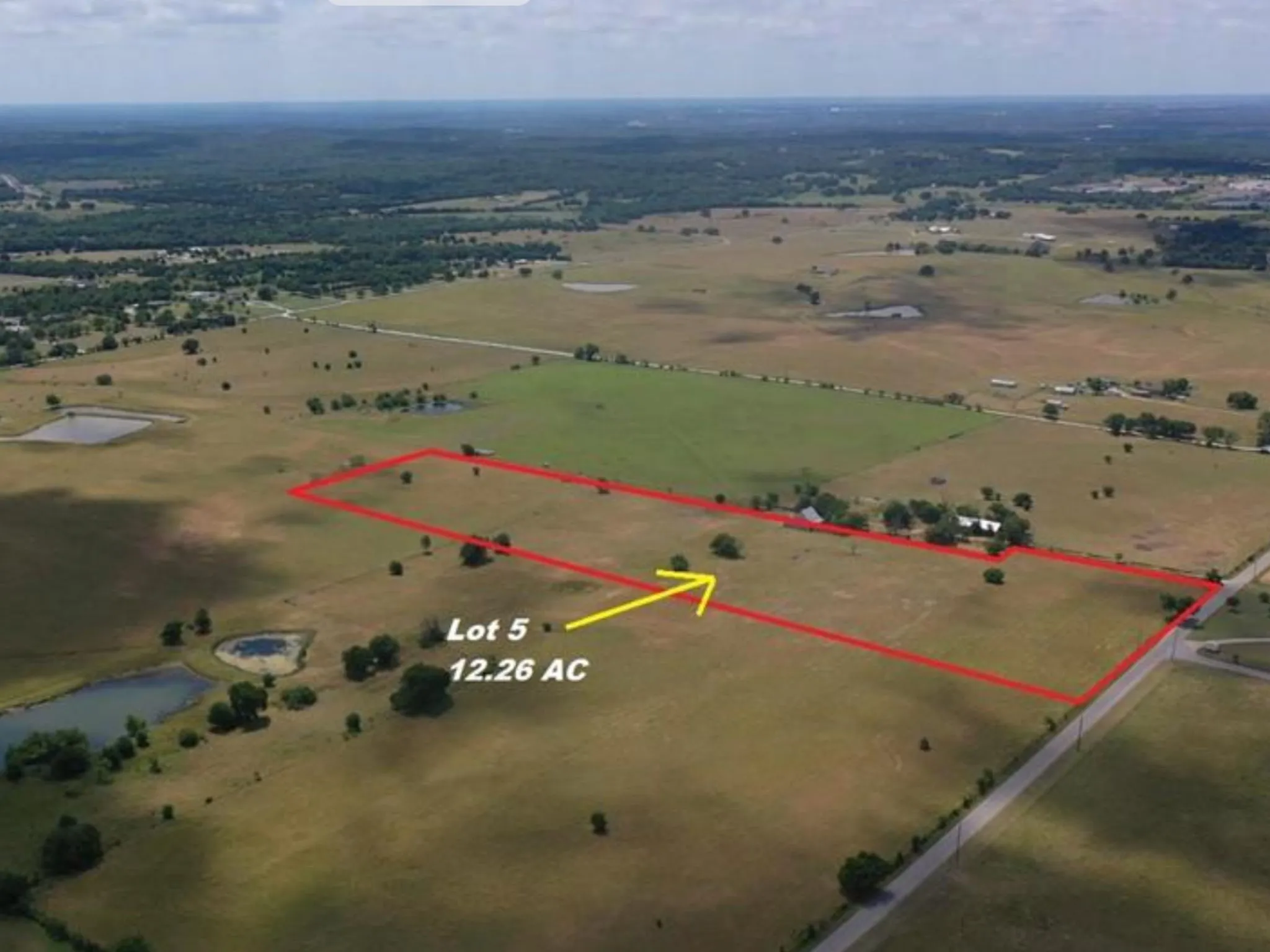 Expansive rural acreage with perimeter boundaries, featuring a contiguous road frontage and distant treelines