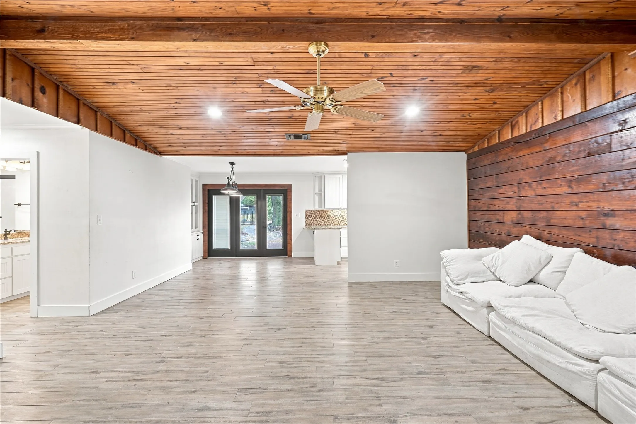 Wood-paneled ceiling with recessed lighting and a ceiling fan