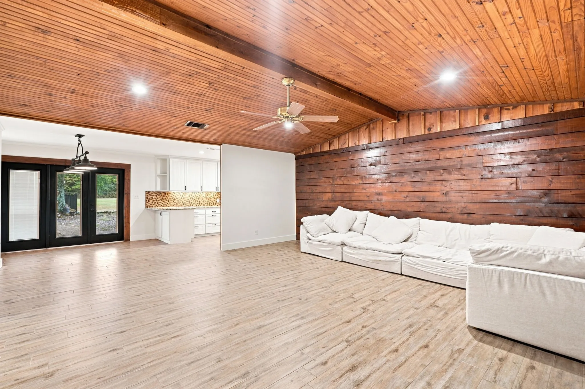 Wood-finish flooring with a wood-paneled ceiling and wall