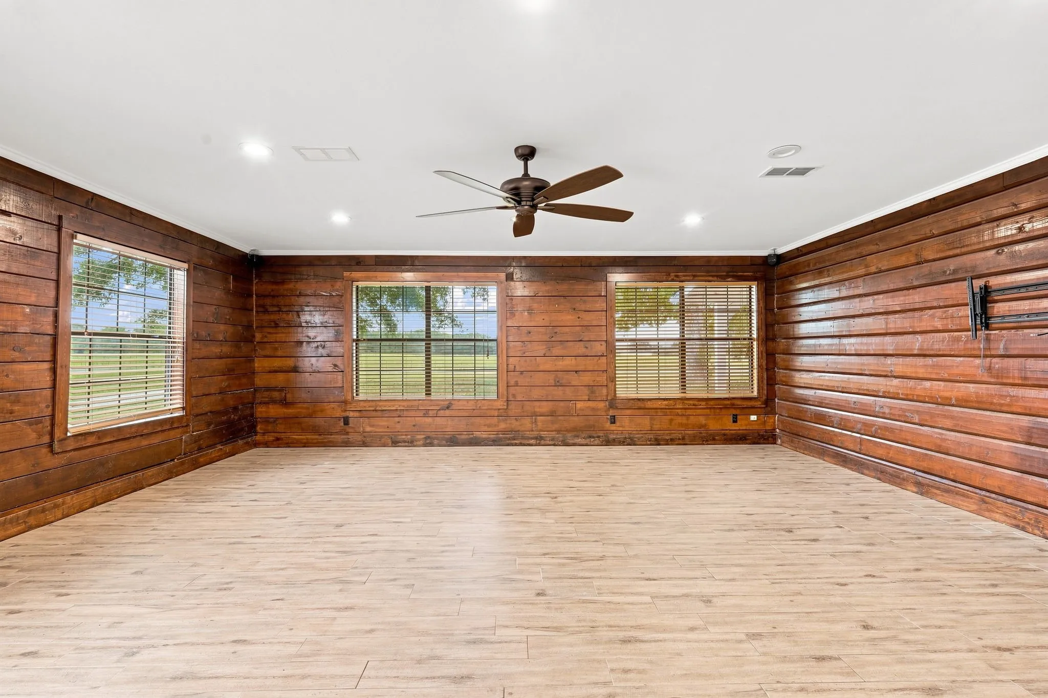 Shiplap wood paneling, recessed lighting, ceiling fan, multiple windows, wood-finish flooring