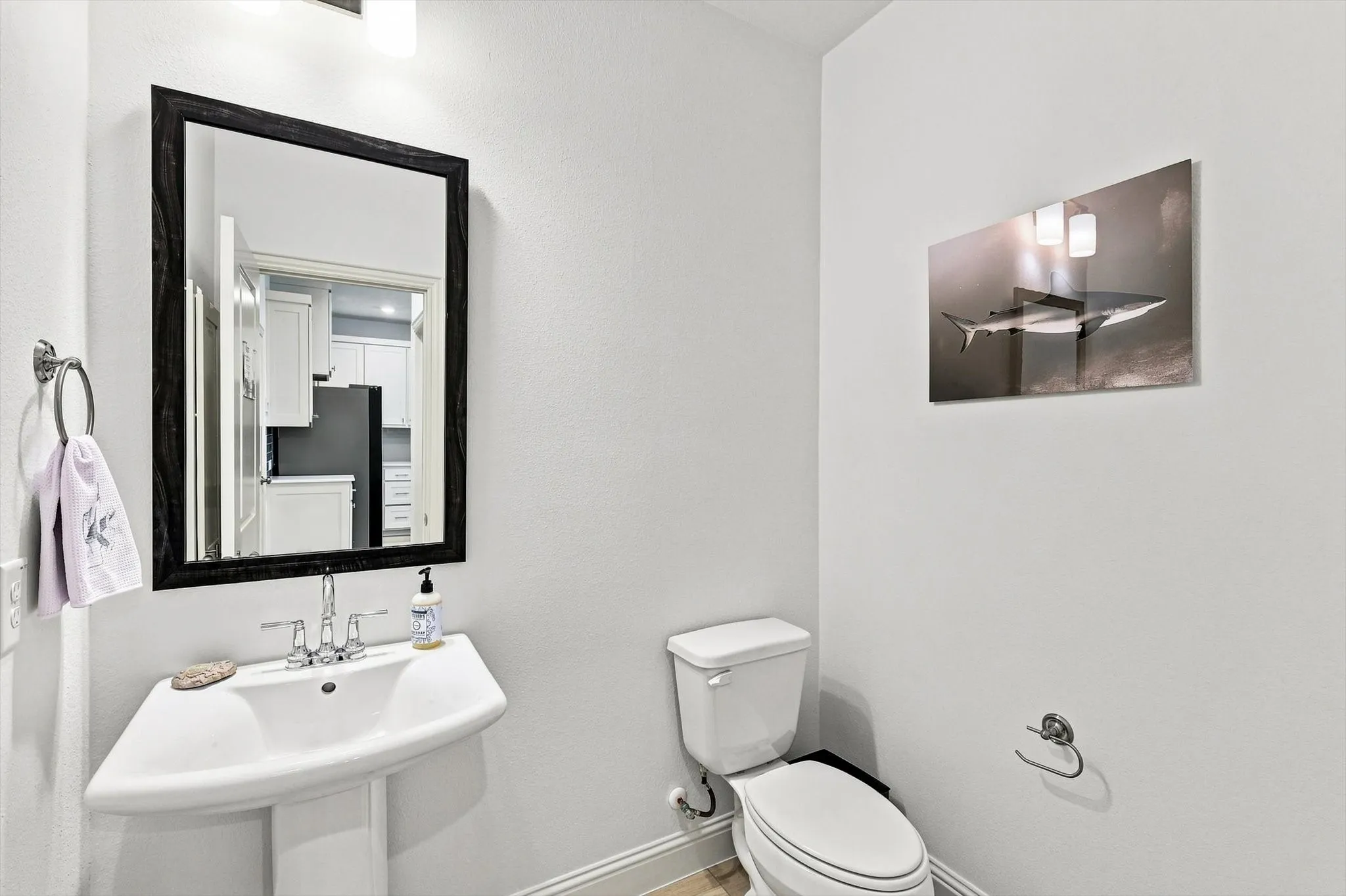 A conveniently located main-level powder bath adds everyday function while maintaining the home’s clean, contemporary aesthetic.