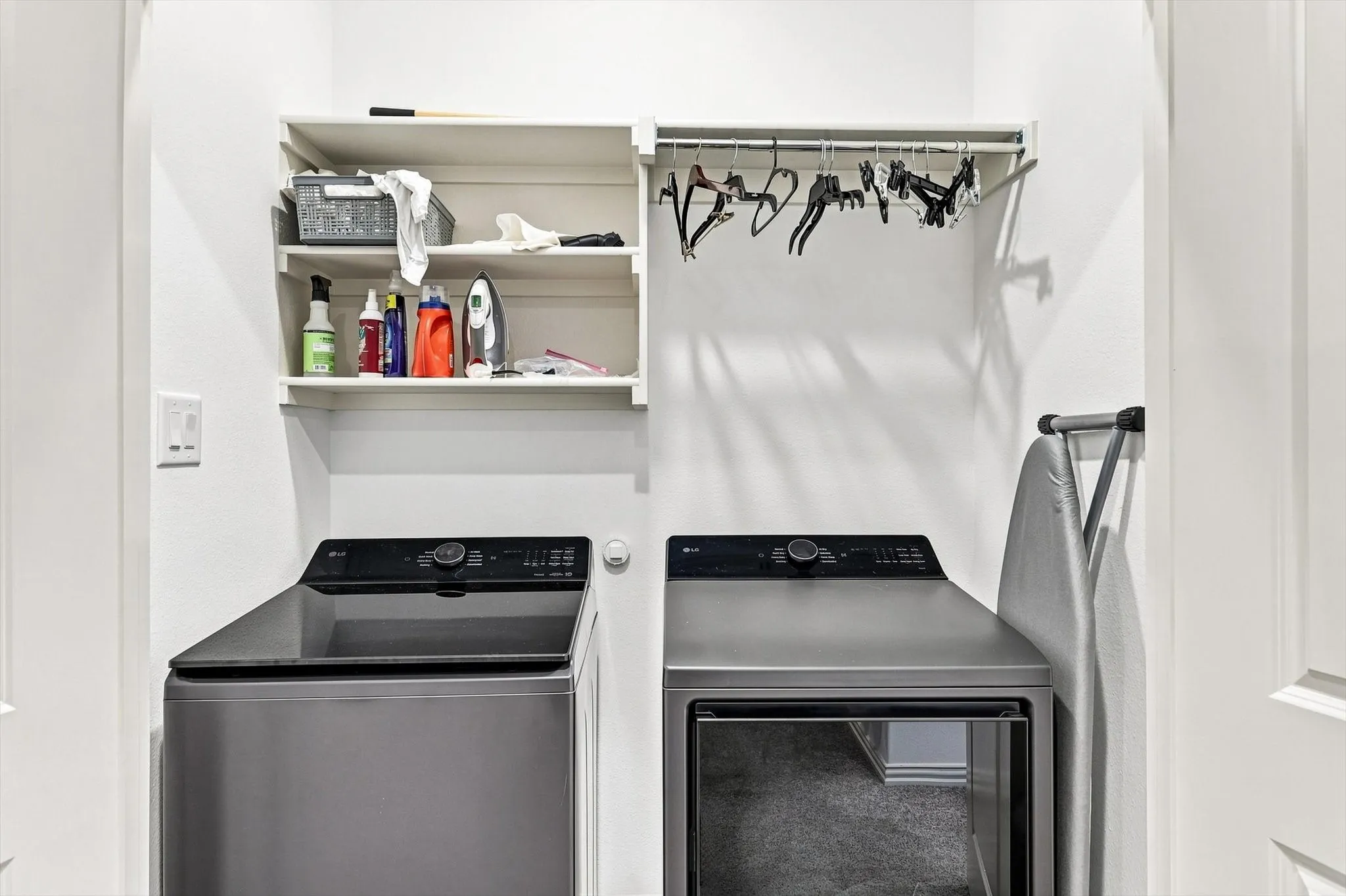 Even laundry day gets an upgrade. A dedicated laundry space with built-in shelving and hanging storage keeps everyday necessities organized and out of sight.