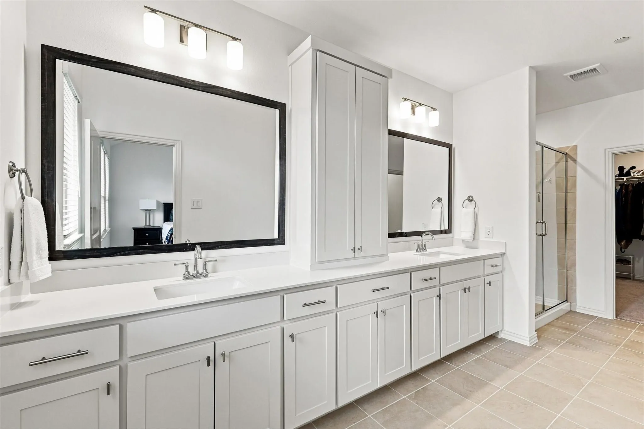 Space to spread out and start the day right. An expansive dual-sink vanity, abundant cabinetry, and oversized mirrors bring both style and function to the primary bath.