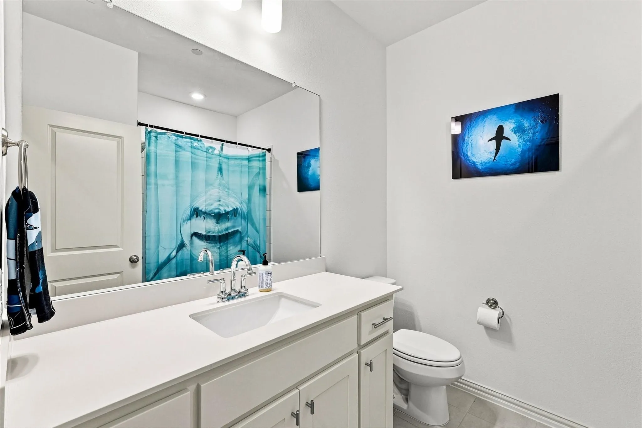 Fresh and functional, this full bath features a clean white vanity, generous counter space, and a bright, polished look.