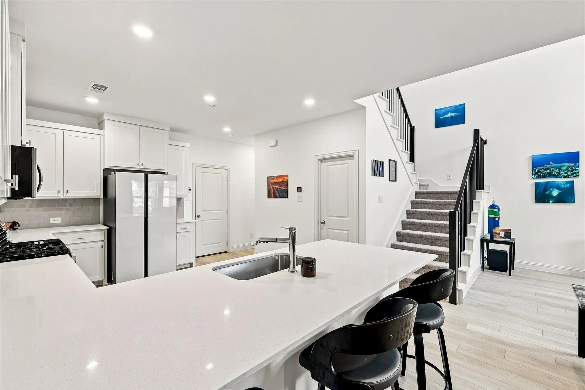 The heart of the home, beautifully connected. An expansive island, bright finishes, and open sightlines create a kitchen designed for gathering, entertaining, and everyday life.