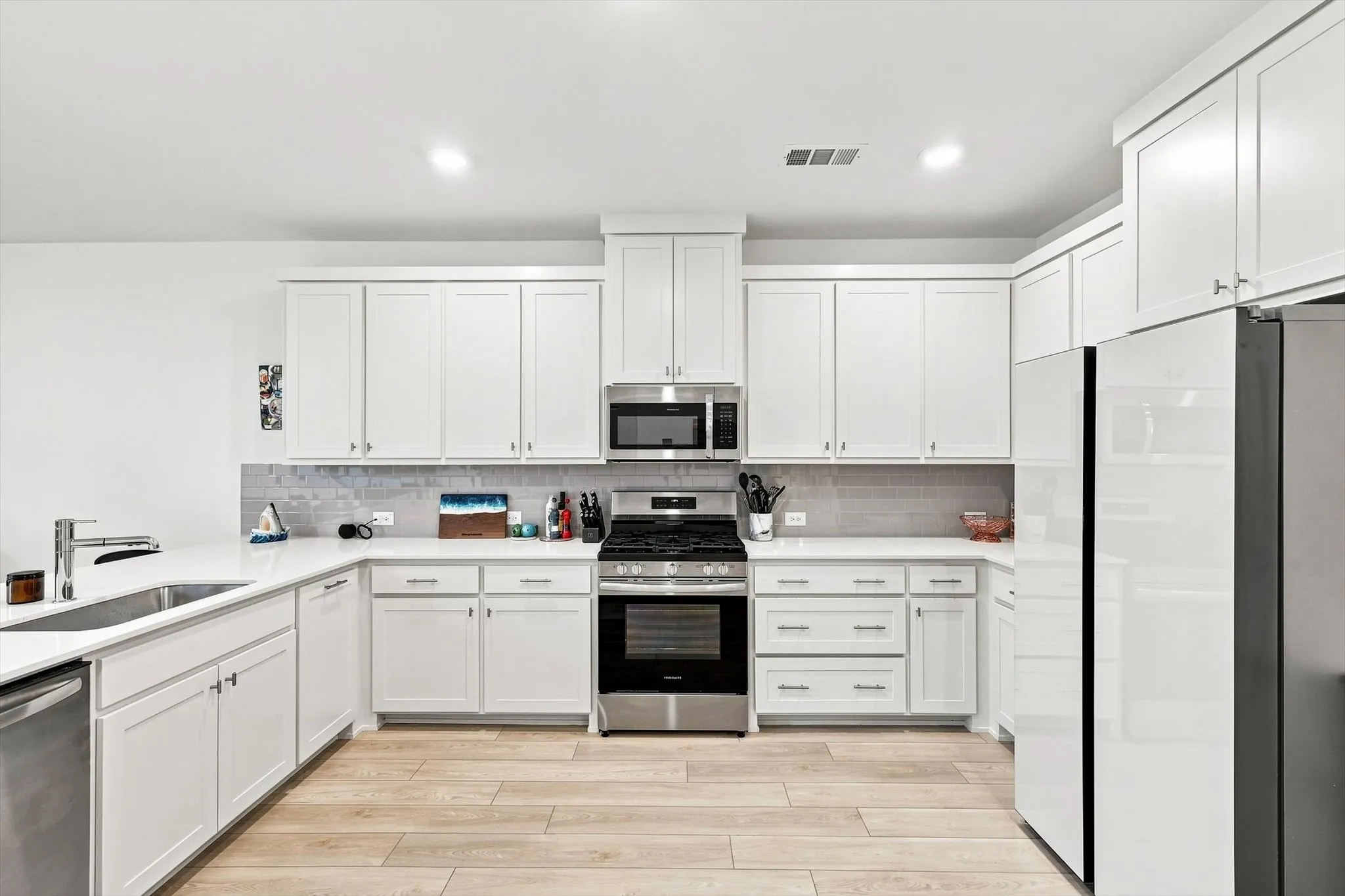 Storage meets style. An impressive wall of cabinetry, abundant counter space, and sleek stainless appliances give this kitchen the clean, elevated look buyers love.
