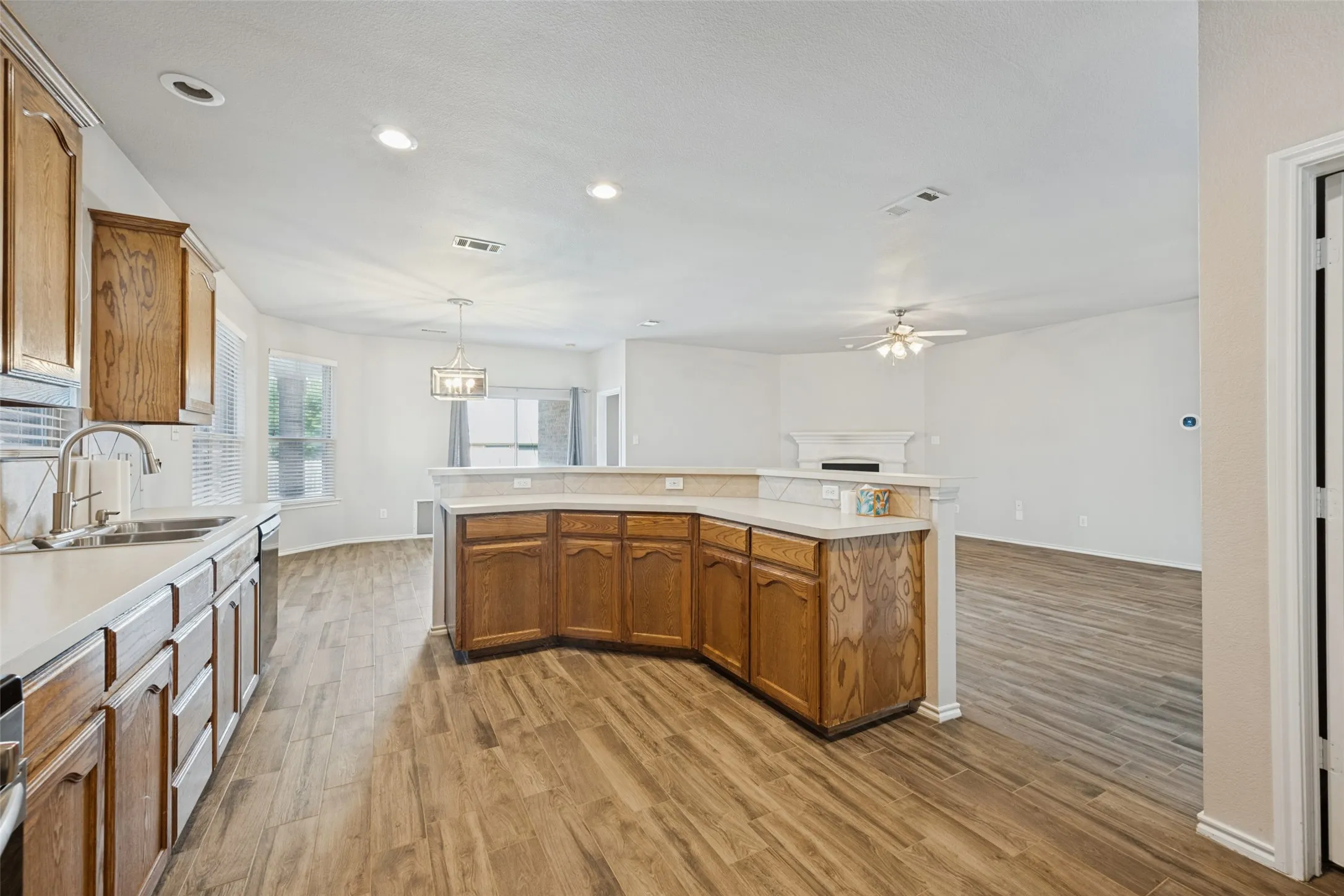 Kitchen featuring wood-finish flooring, wood cabinetry, white countertops, and recessed lighting