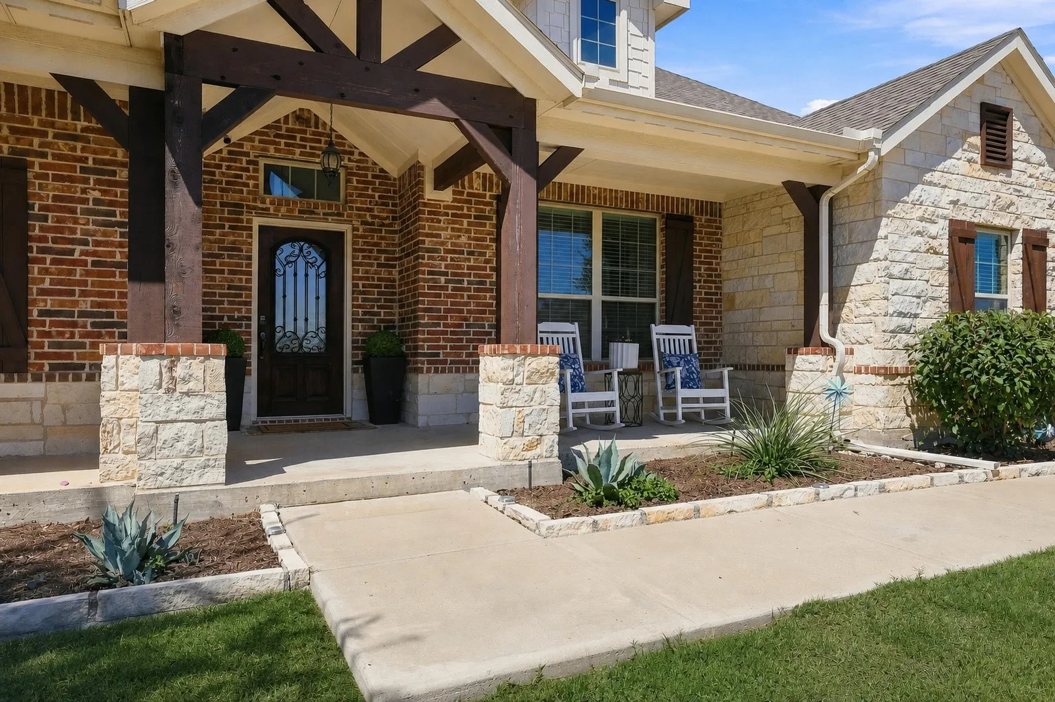 Stone Exterior, Wood and Iron Door, Porch made for Sitting.