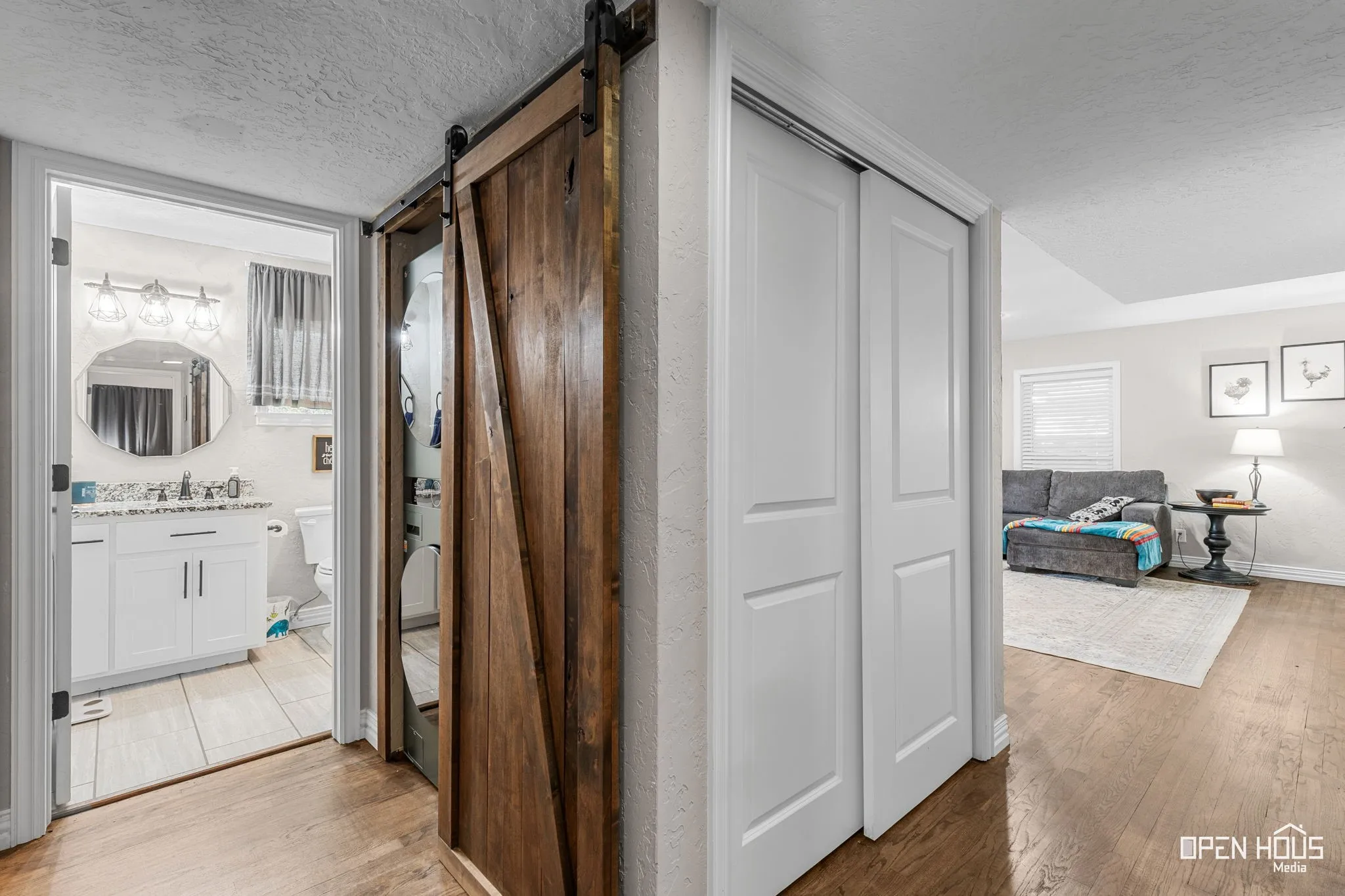 Wood-finish flooring throughout, barn door entry, and white sliding closet doors