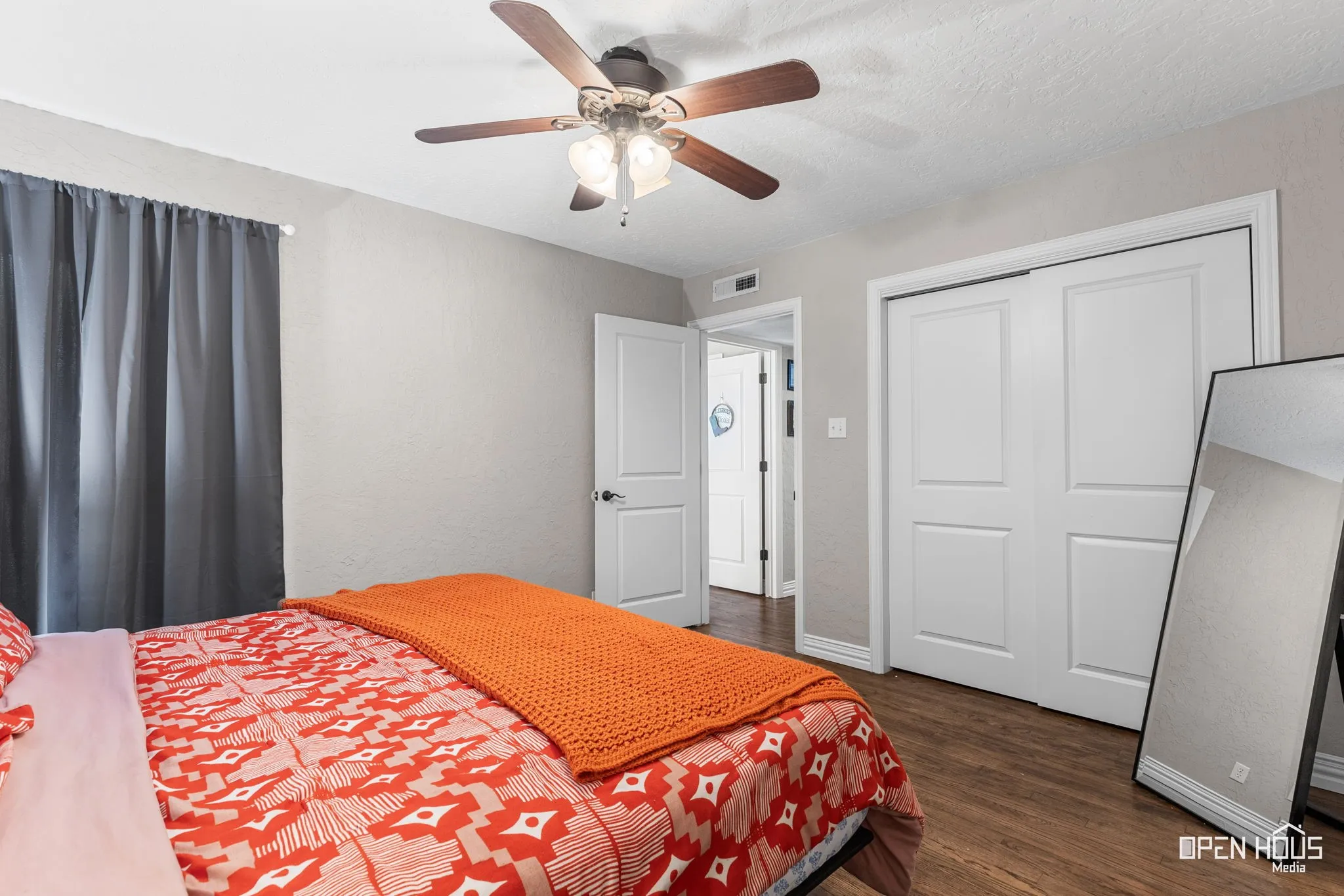 Wood-finish flooring, white paneled doors, ceiling fan with integrated lighting, and neutral wall tones