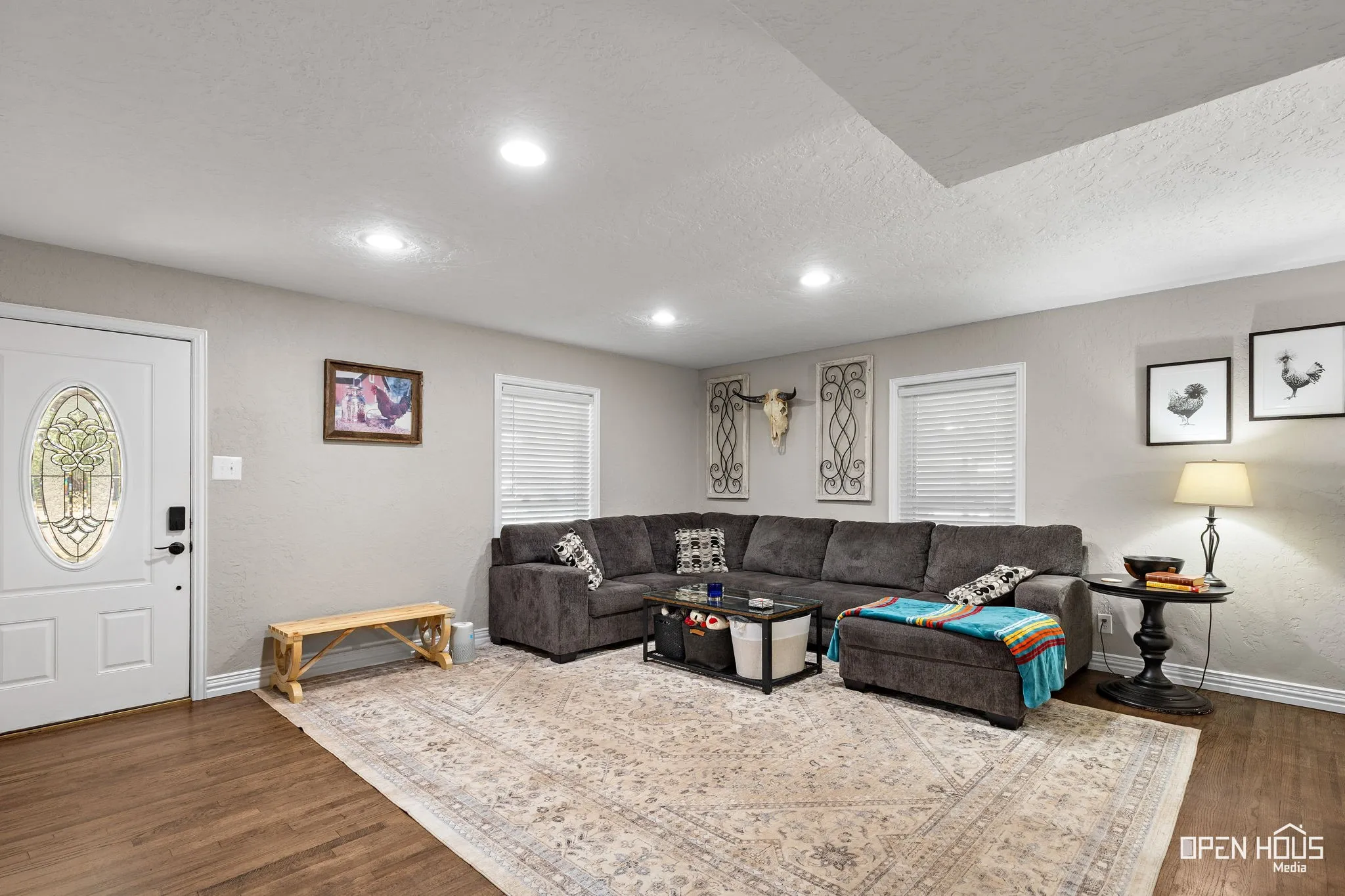 Wood-finish flooring, recessed lighting, and a white entry door with decorative glass