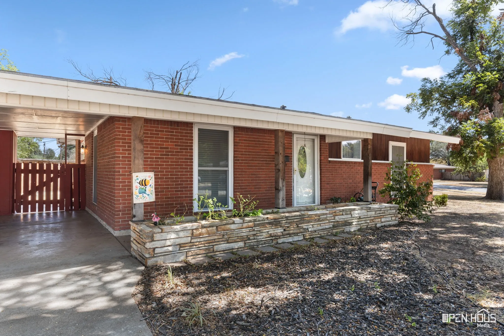 Brick exterior with wood-clad accents, stone-clad planter box, and a covered entryway