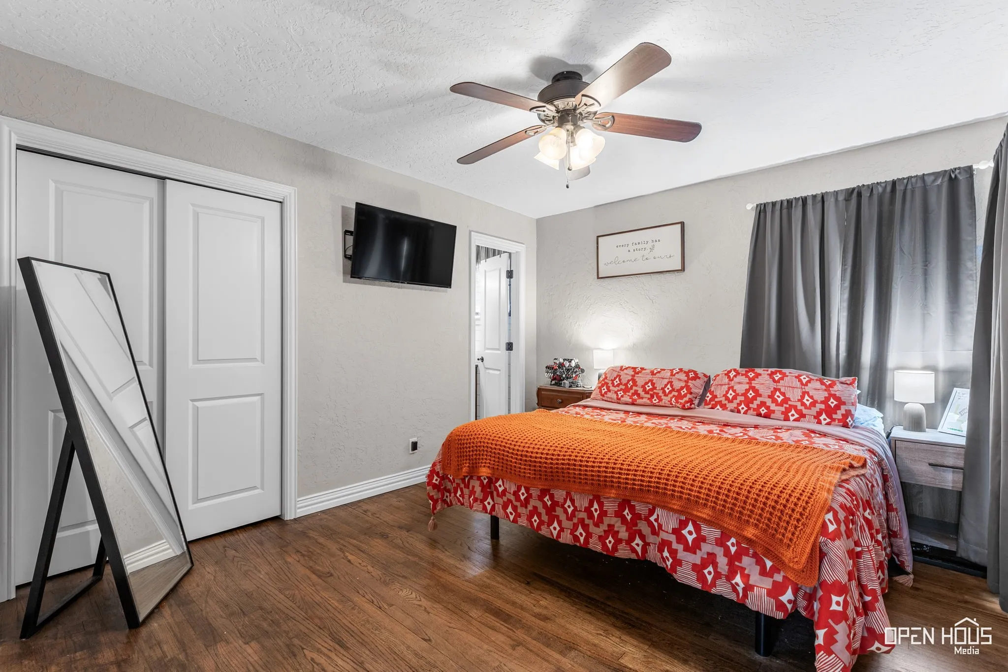 Wood-finish flooring with white trim, two-panel interior doors, and a ceiling fan with integrated lighting