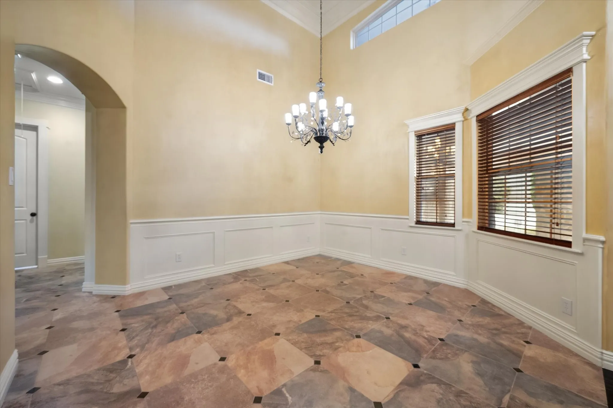 This dining room will accommodate a large table.  Arched doorway and beautiful crown molding and window trim