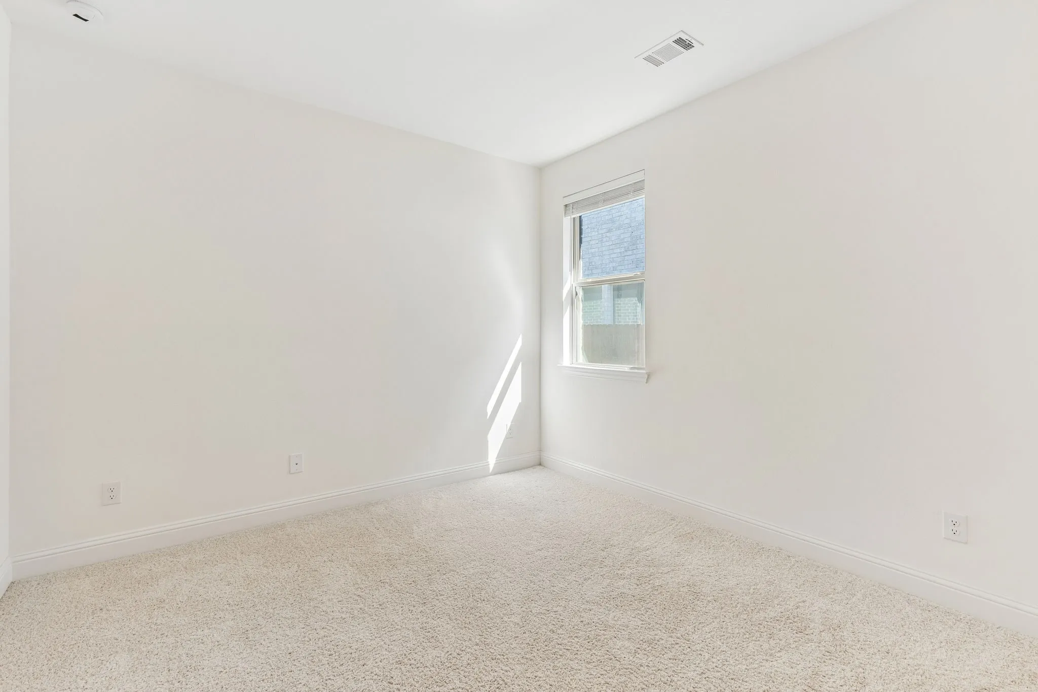 Neutral wall finishes, light-toned carpeting, and a double-hung window
