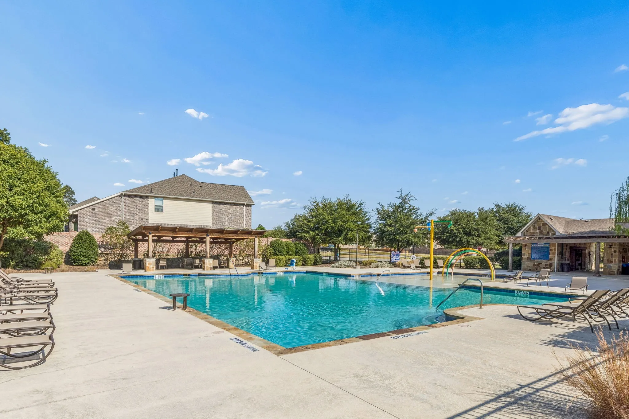 Expansive community pool with integrated splash pad and shallow entry