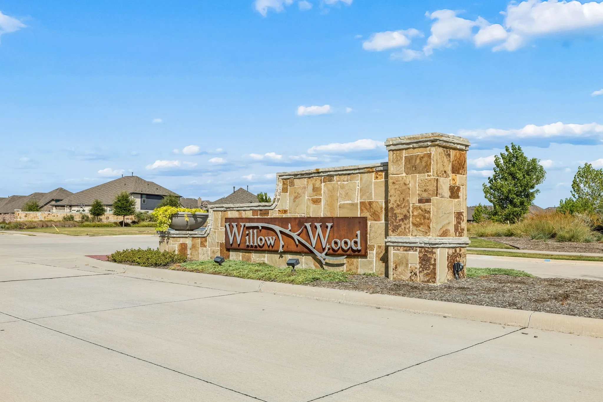 Stone monument sign with integrated landscaping and exterior lighting
