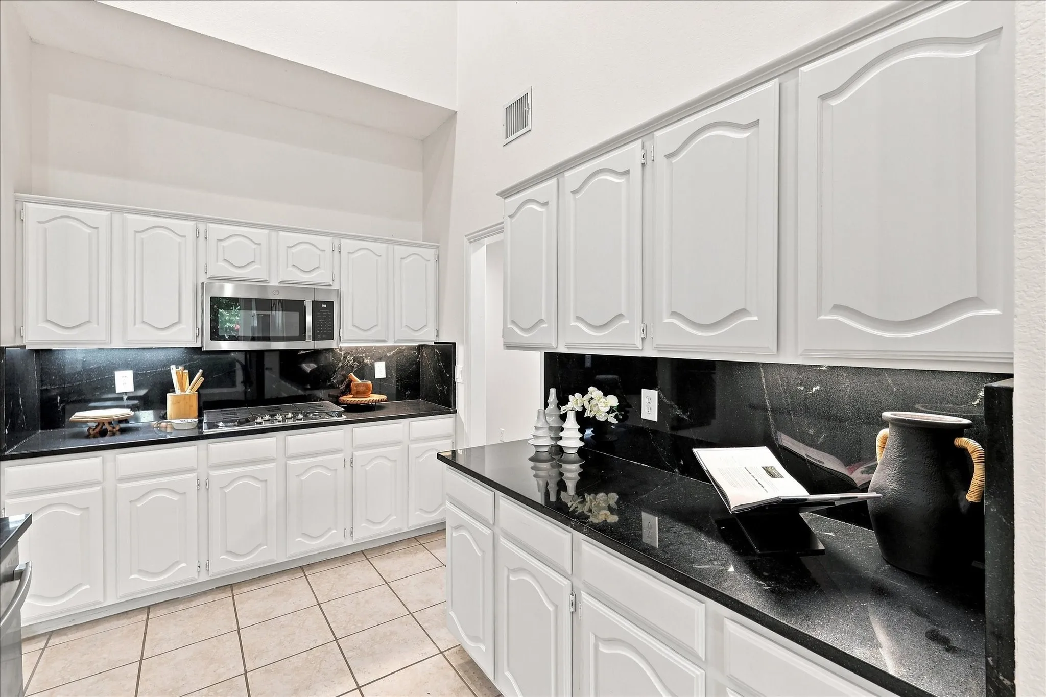 A kitchen made for gathering, with bold black granite countertops, a modern backsplash, and stainless steel appliances that bring a fresh, polished feel to the space. It’s the kind of kitchen where everyday meals turn into time together.