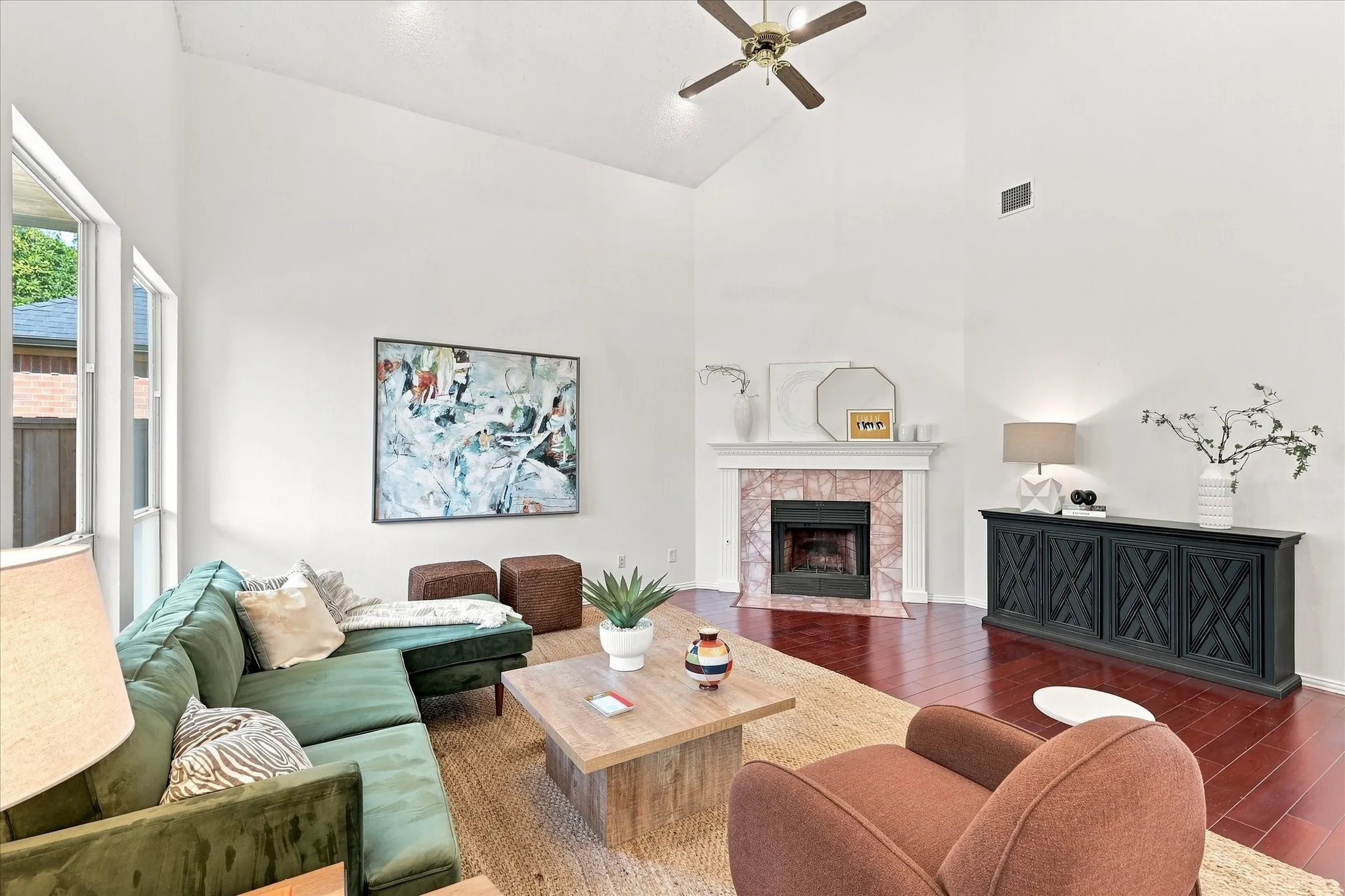 Warm wood floors, soaring ceilings, and a striking fireplace give this family room maximum visual impact while creating a space that feels made for gathering.