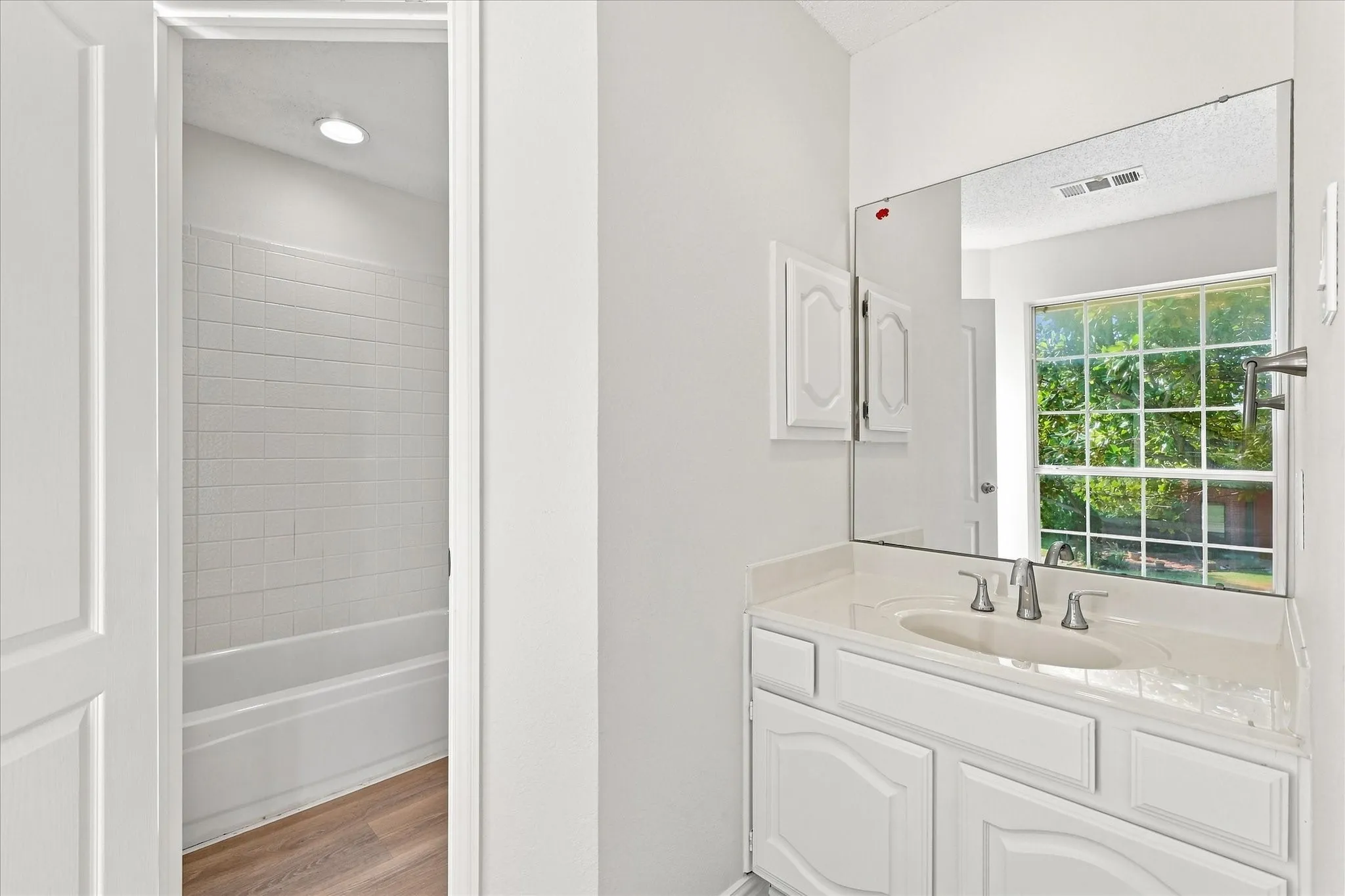 Jack-and-Jill bath with easy-to-maintain LVP flooring, making busy mornings and getting ready a breeze.