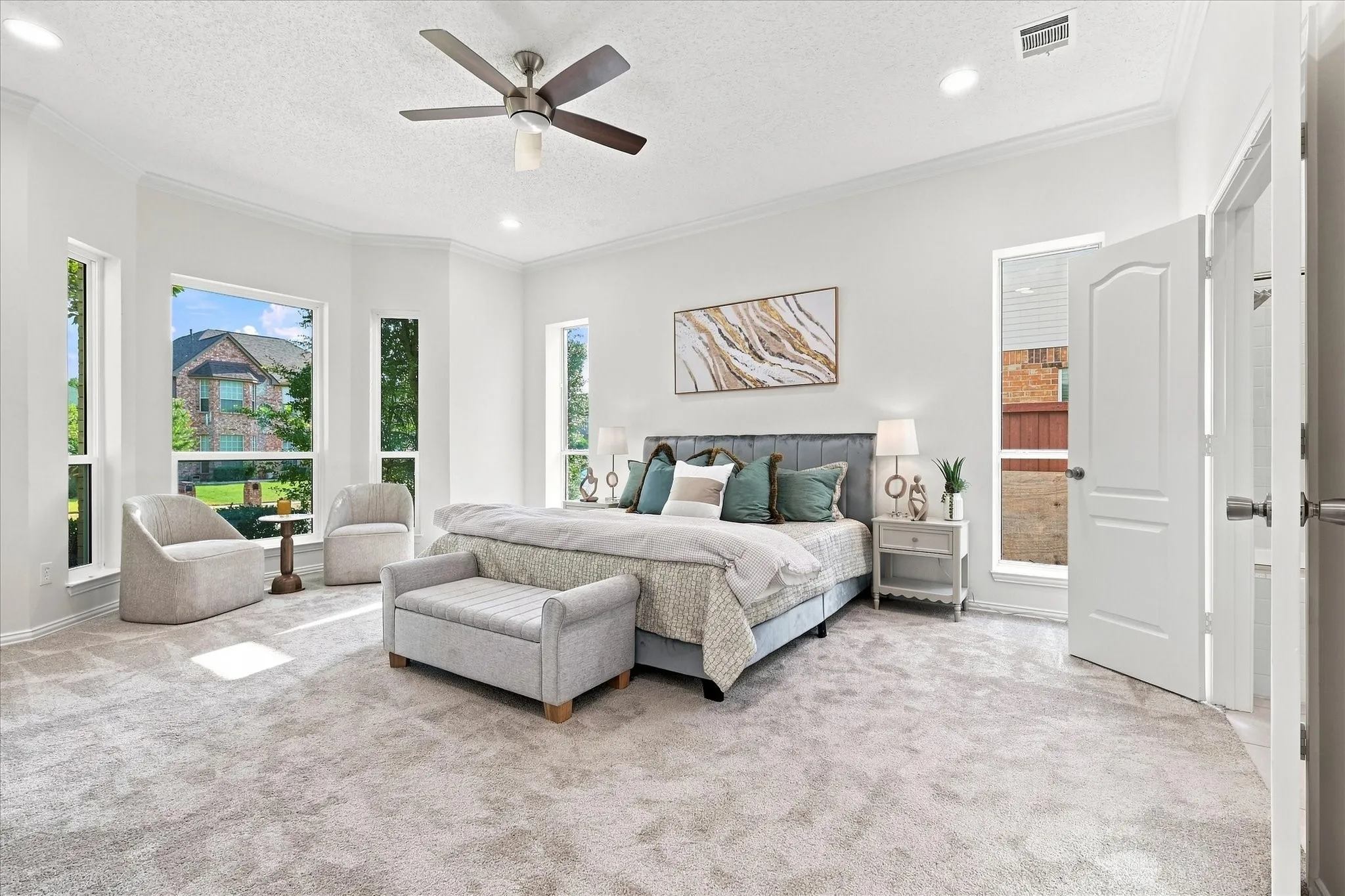 A spacious primary bedroom with fresh white walls and new carpet creates a bright, comfortable retreat at the end of the day.