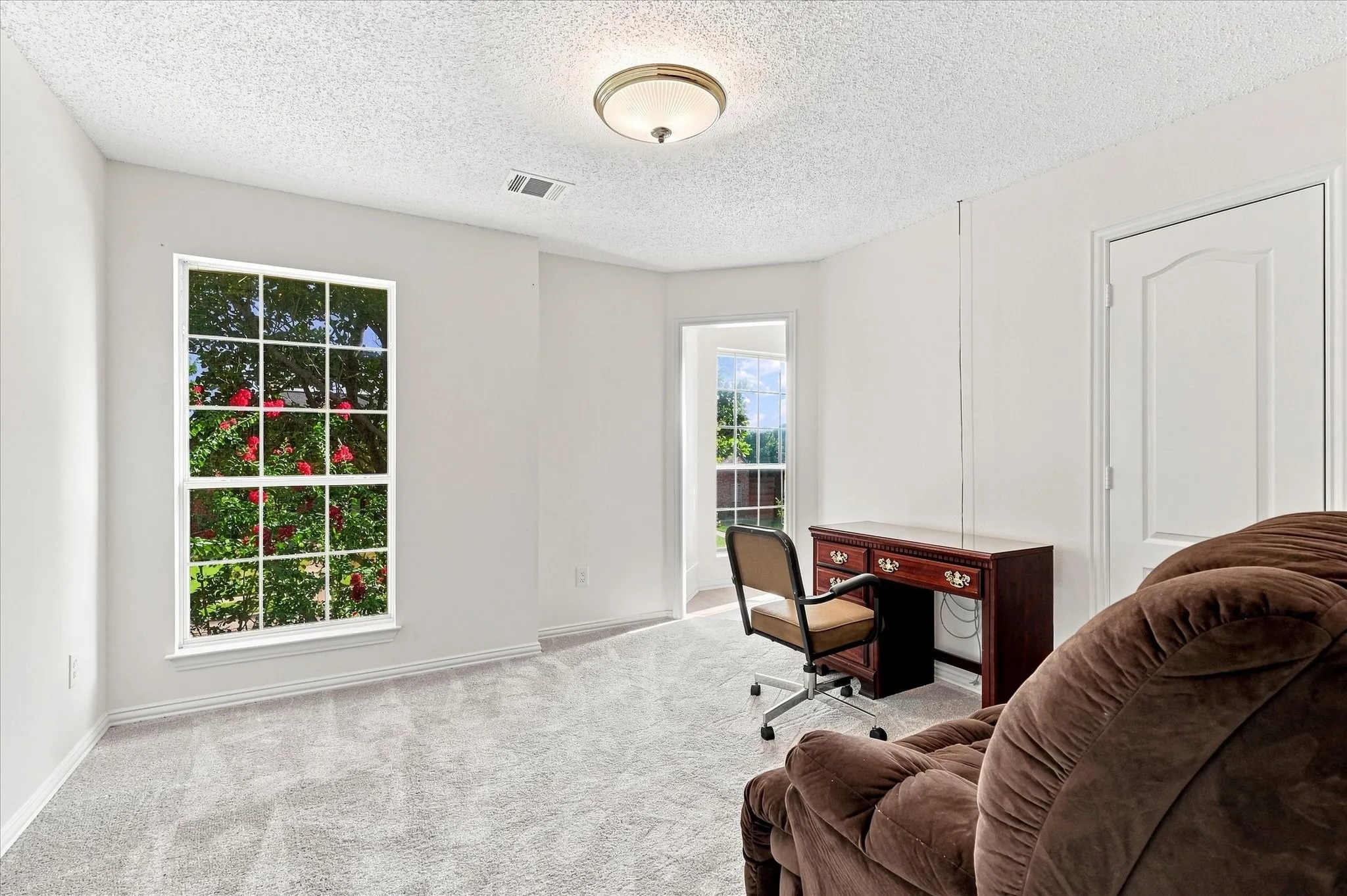 Here’s the same bedroom without the virtual staging, so you can see the space as it is—with new carpet and a Jack-and-Jill bath.