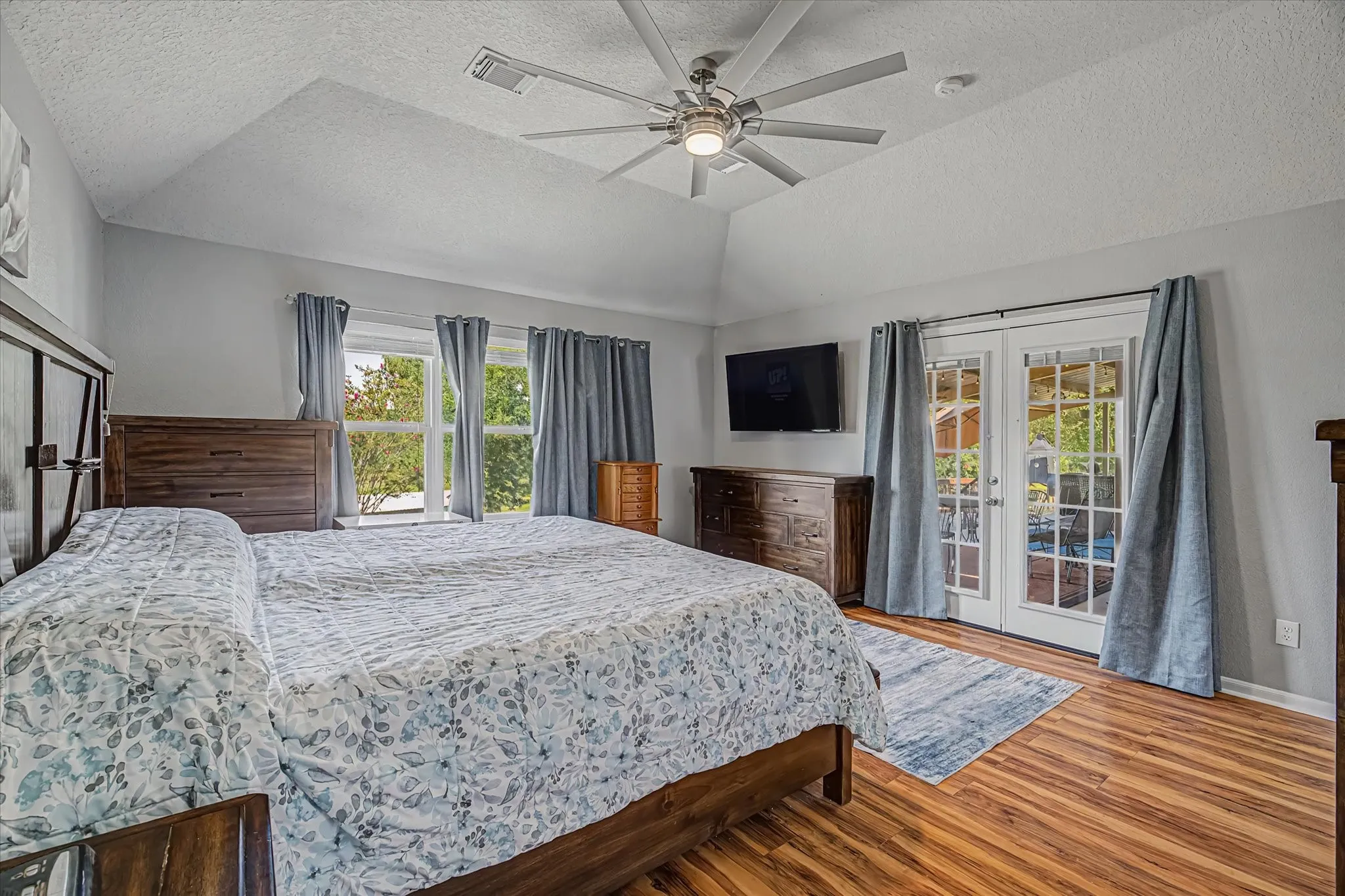 Vaulted ceiling with a ceiling fan and French doors