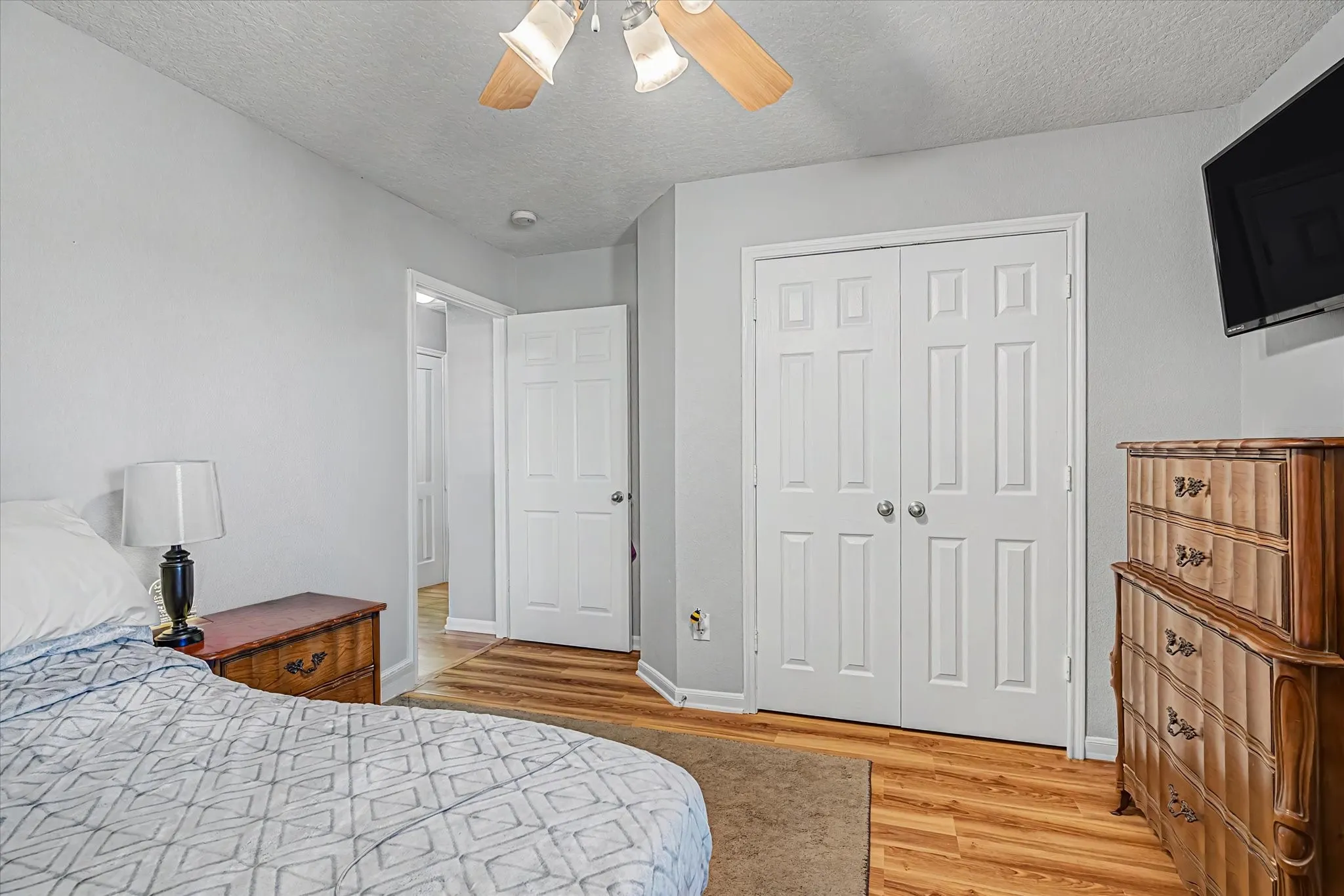 2nd bedroom w/ closet doors, and light gray wall paint