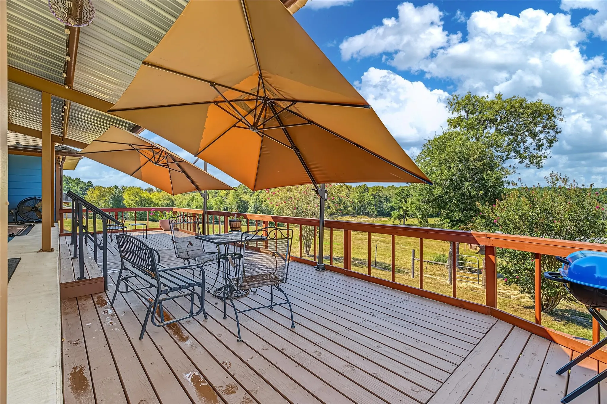 Expansive outdoor deck with wood-finish flooring and a protective corrugated metal roof